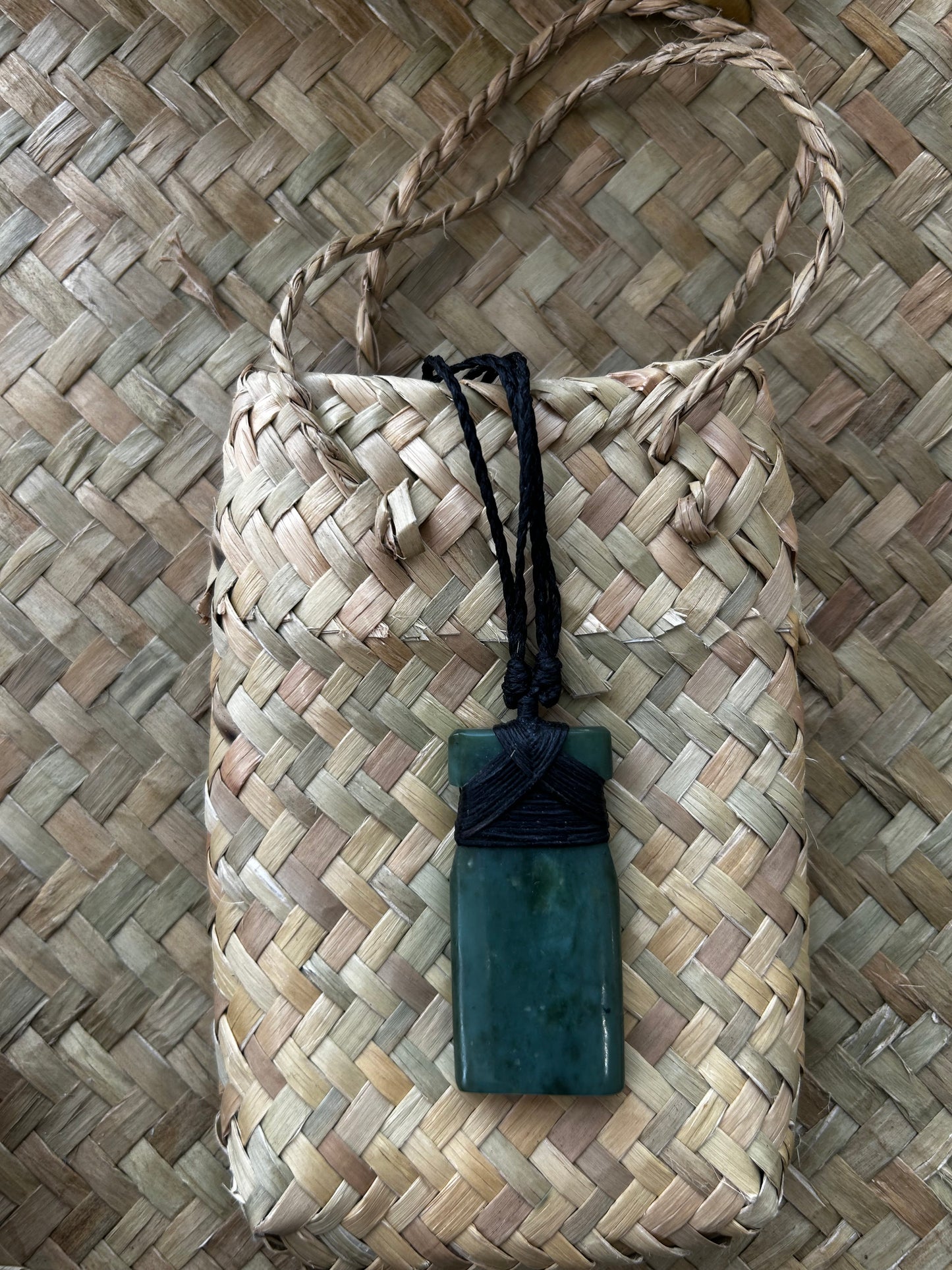 carved pounamu toki (adze) necklace with black lashing