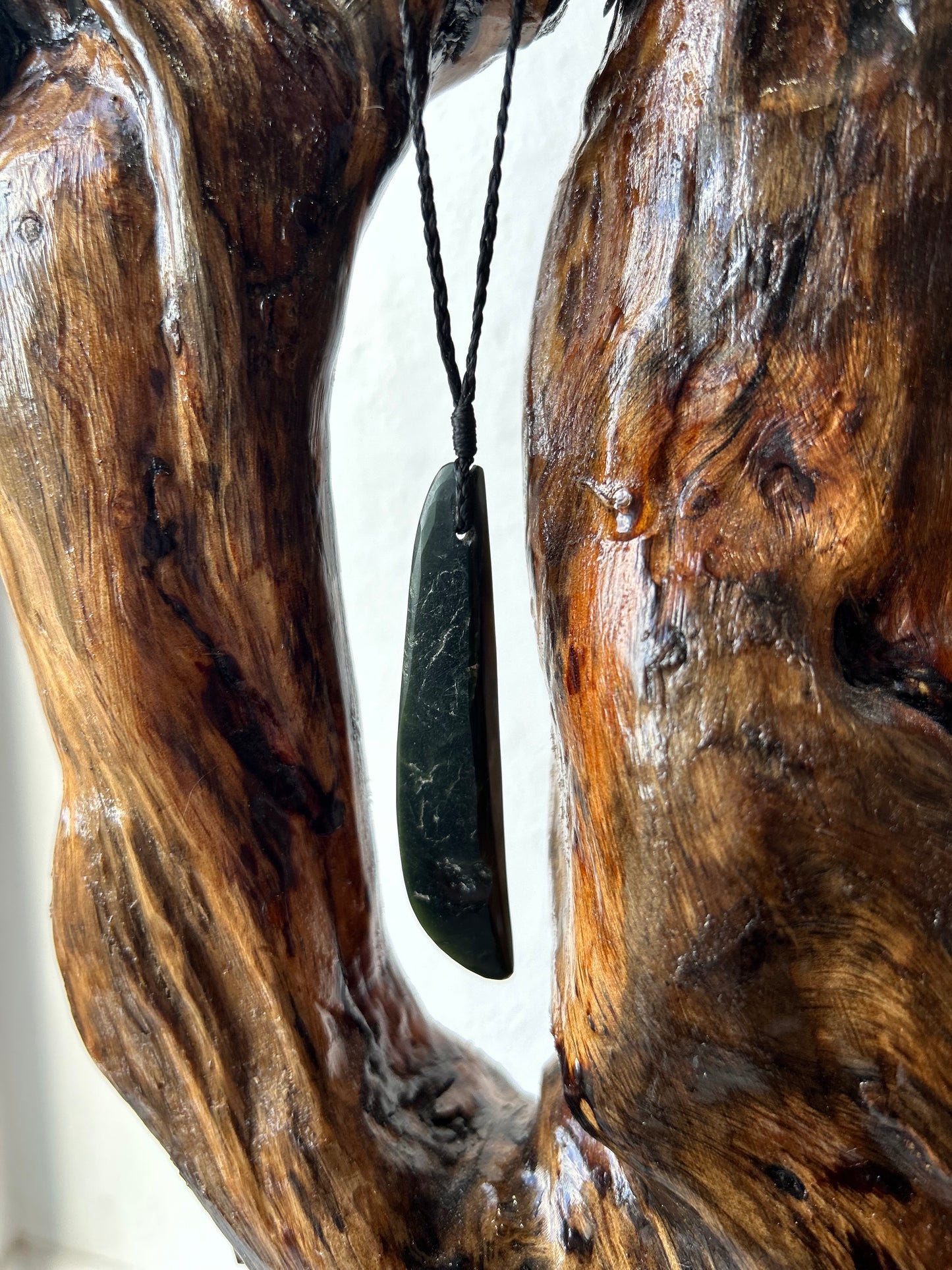 dark green carved pounamu roimata (tear drop) necklace on black cord with a pointed base