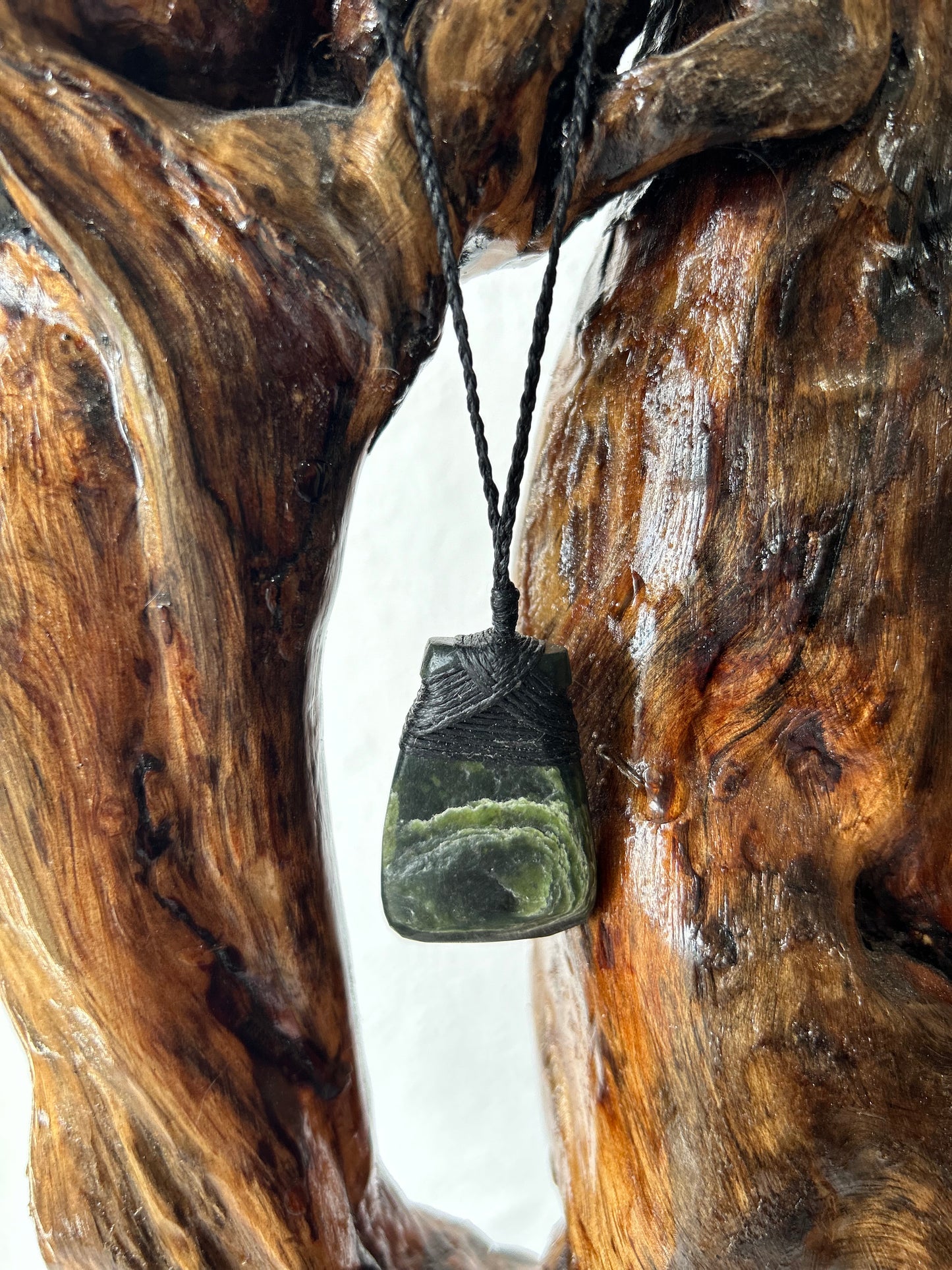 carved pounamu toki (adze) necklace with beautiful white colour inclusions and black lashing