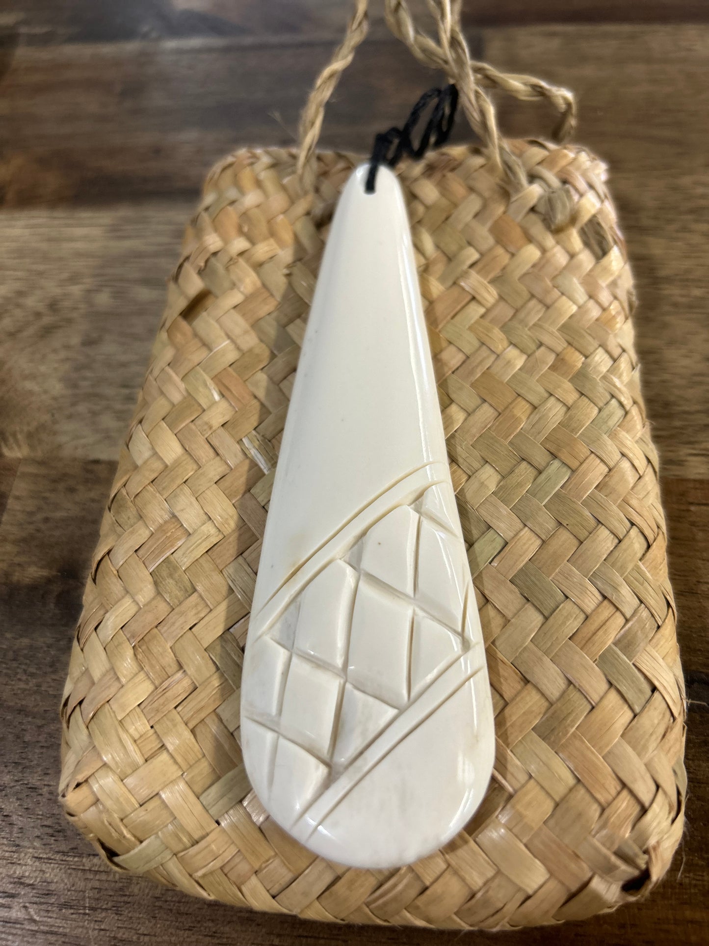 carved bone roimata (tear drop) with carved designs on black cord