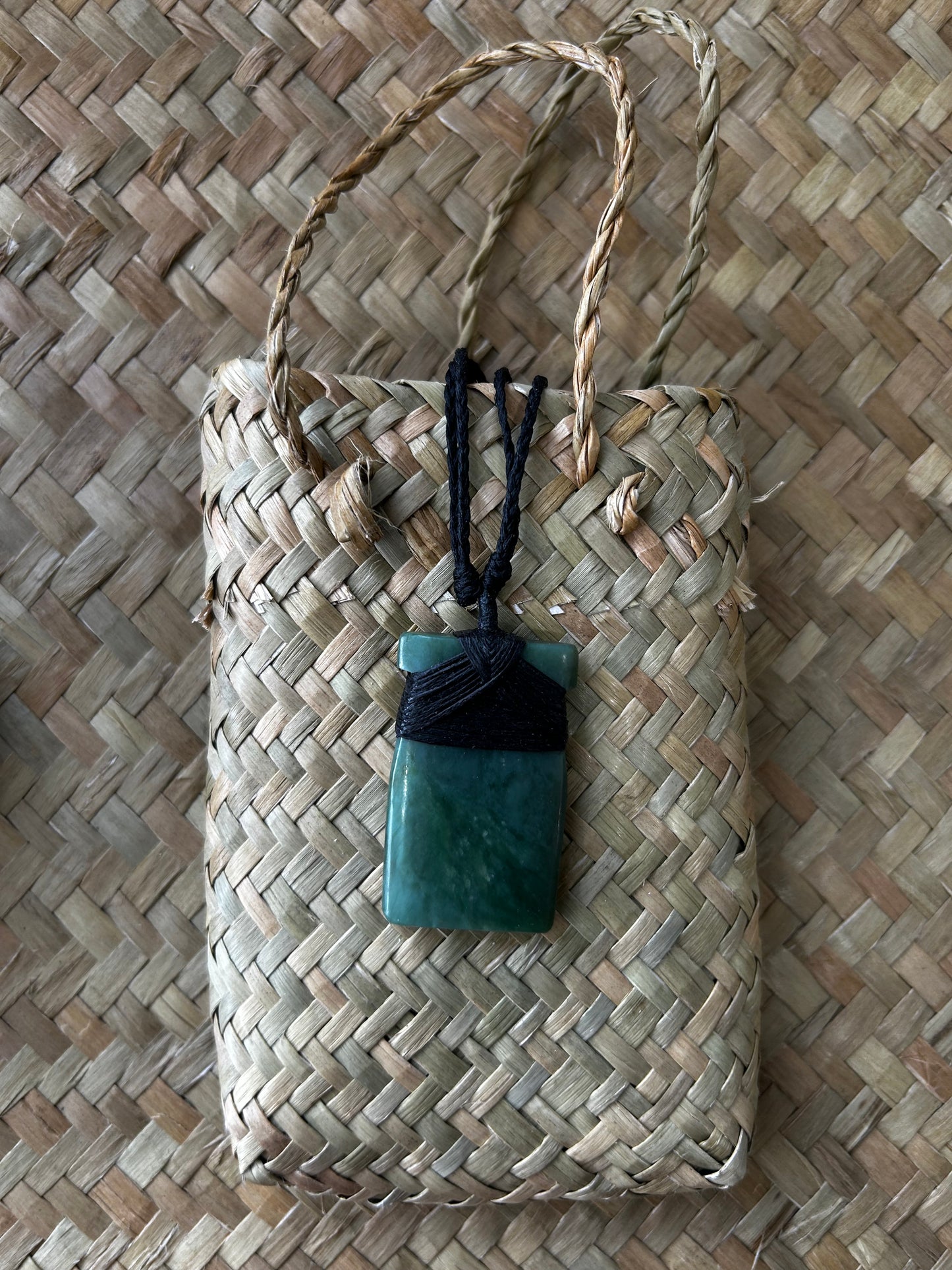 carved pounamu toki (adze) necklace with black lashing