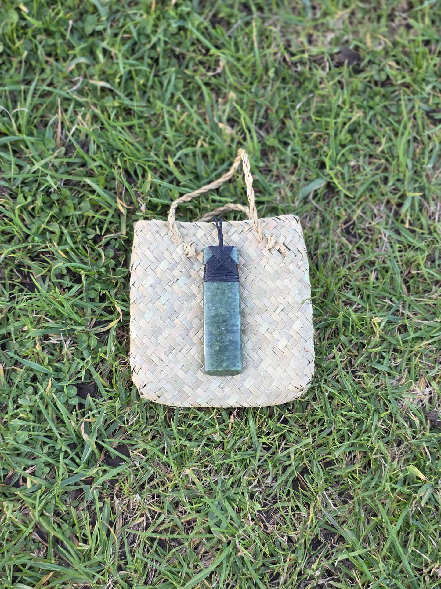 Light green pounamu greenstone toki (adze) necklace with black strapping