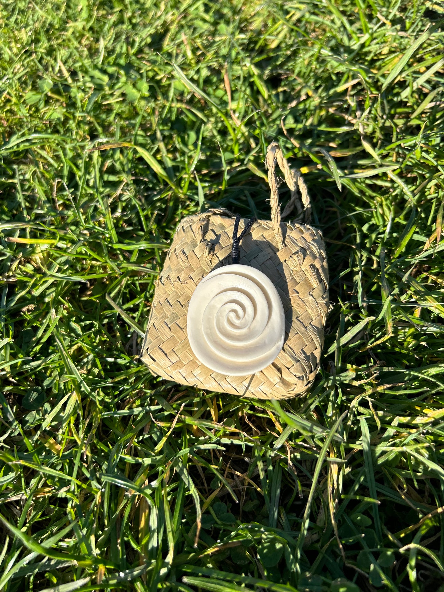 Carved bone takarangi (double spiral) necklace on black braiding