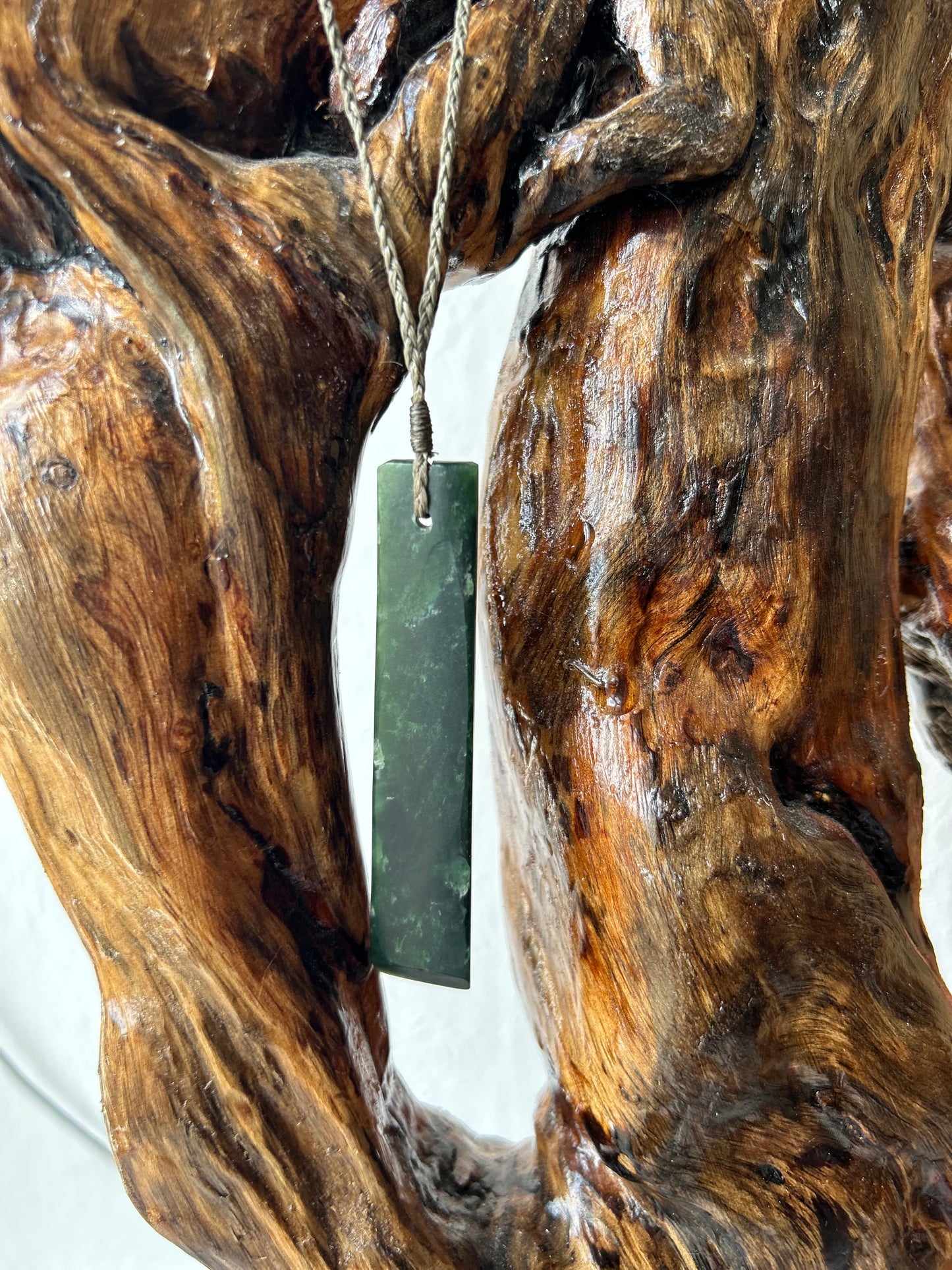 carved pounamu toki (adze) necklace with white colour inclusions on black cord