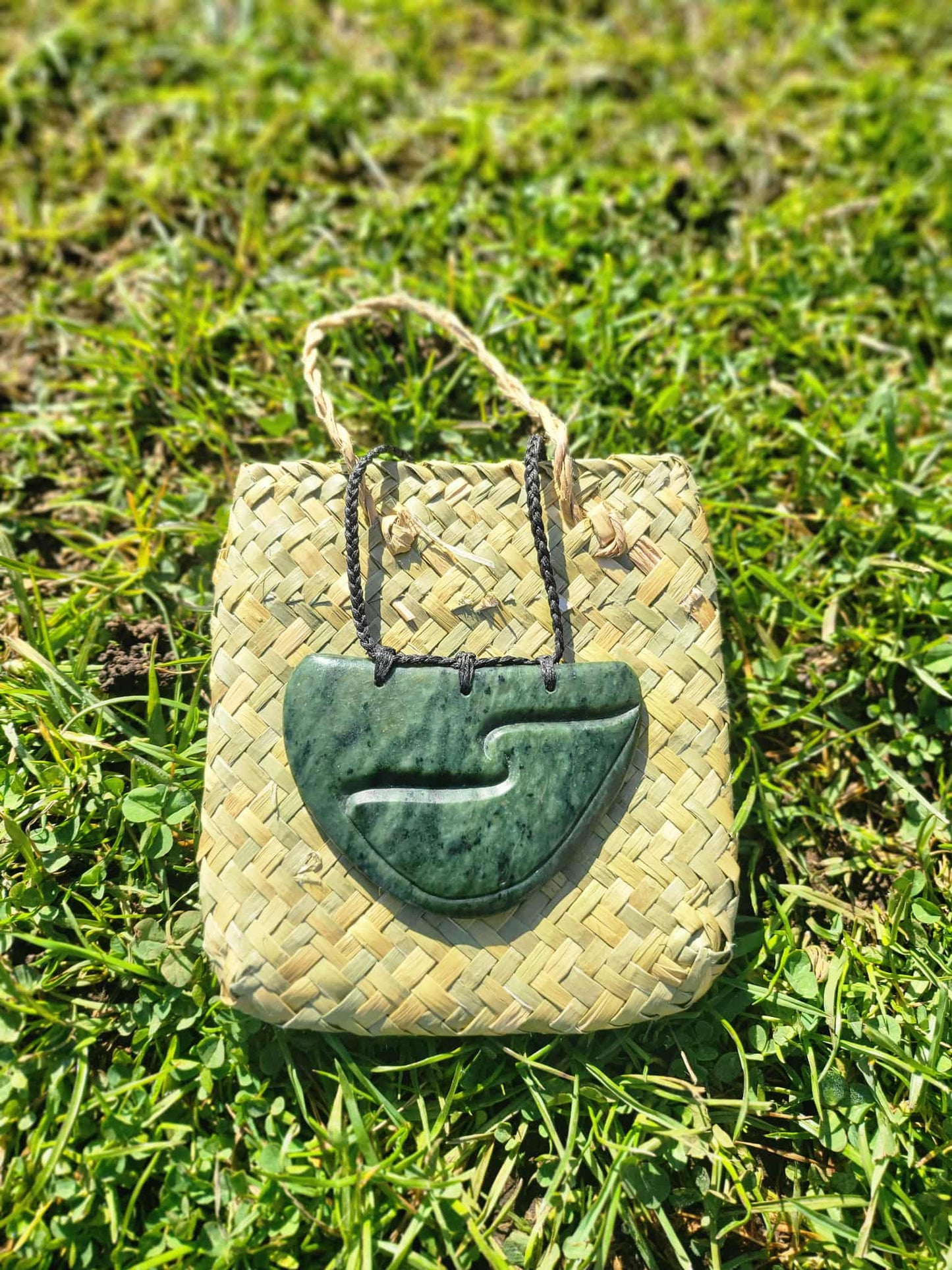 Pounamu (greenstone) breastplate necklace on black braiding with tino rangatiratanga carved design