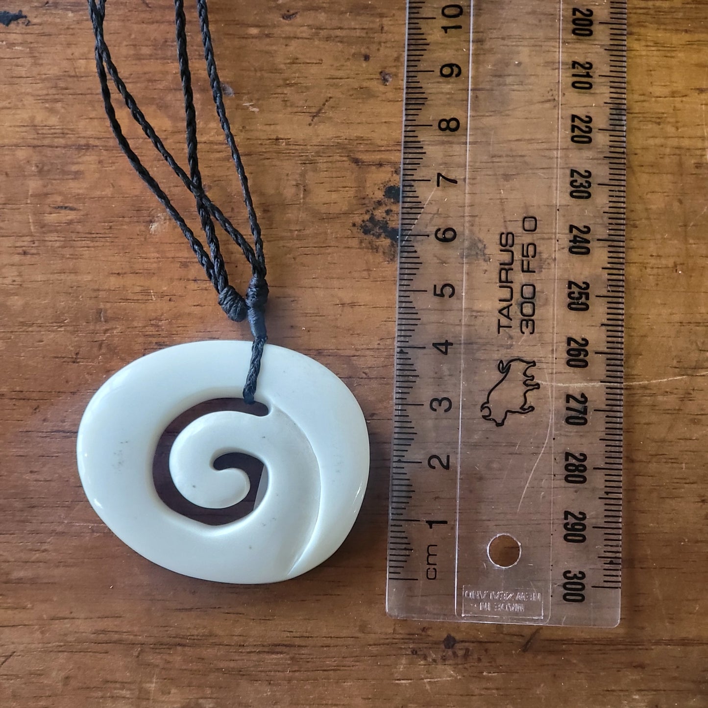 carved bone koru (spiral) necklace on black cord
