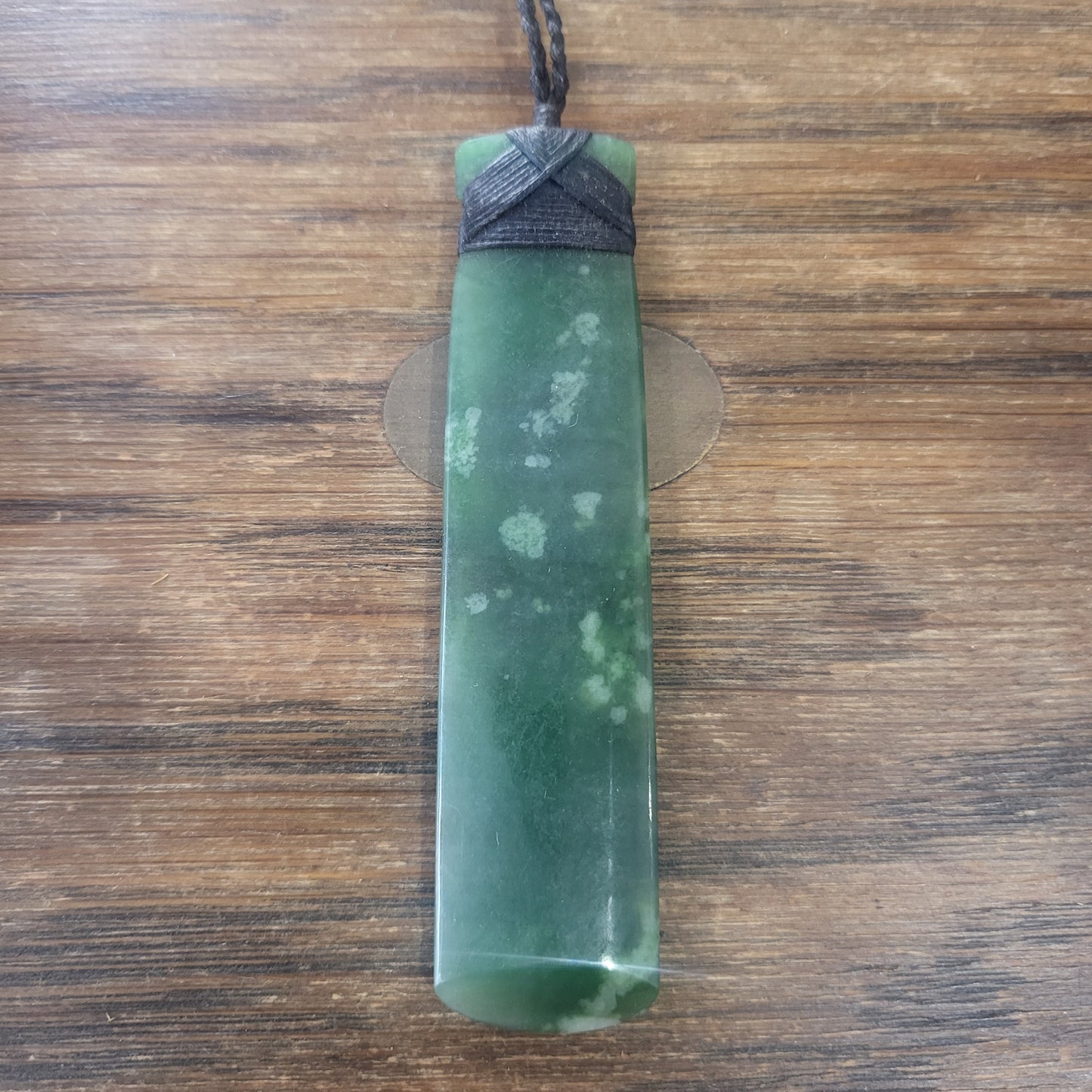 carved pounamu toki (adze) necklace with black lashing, beautiful white colour inclusions