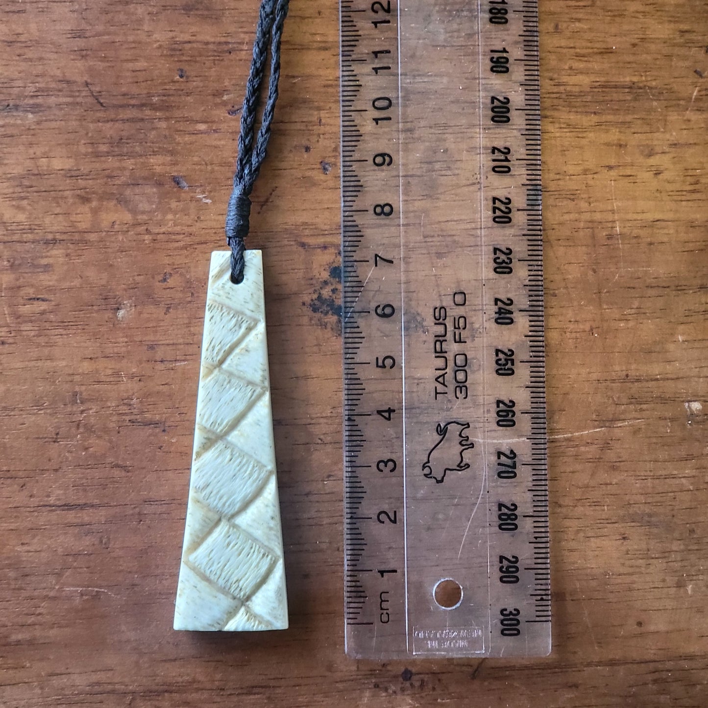 carved bone toki (adze) necklace on black cord with carved raranga (weaving) designs