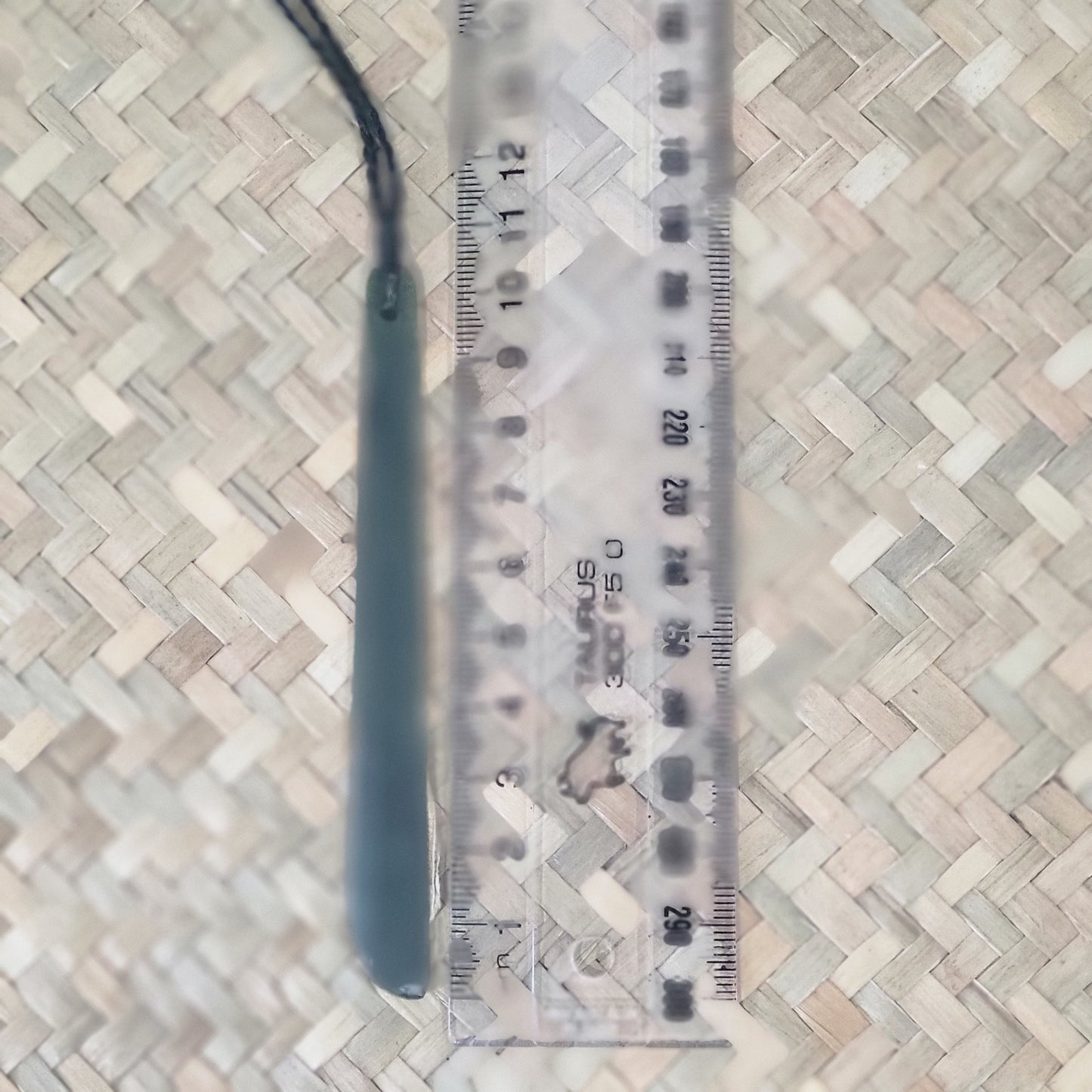 long thin carved pounamu roimata (tear drop) necklace, on black cord