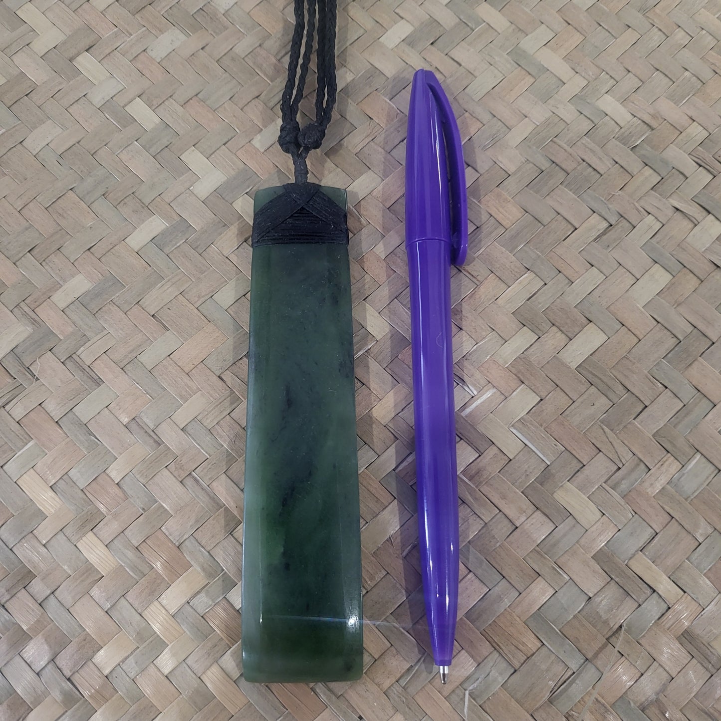 carved pounamu toki (adze) necklace with bevelled edges and black lashing