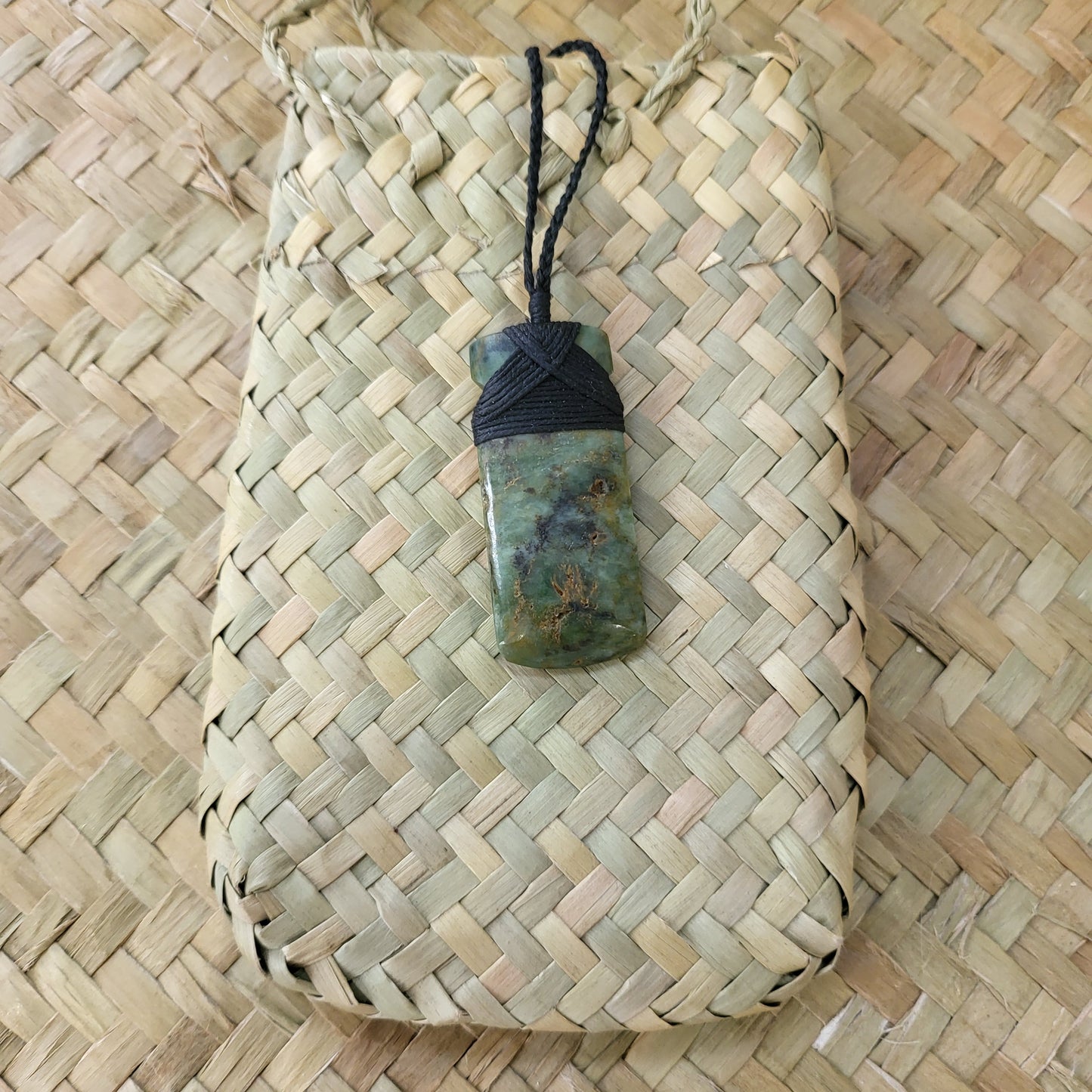 small carved pounamu toki (adze) necklace light green colour variations on black cord