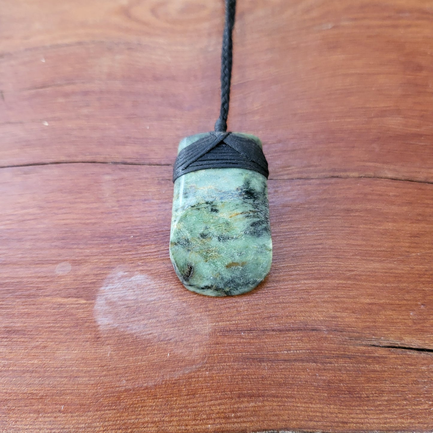 small carved pounamu toki (adze) necklace light green colour variations on black cord
