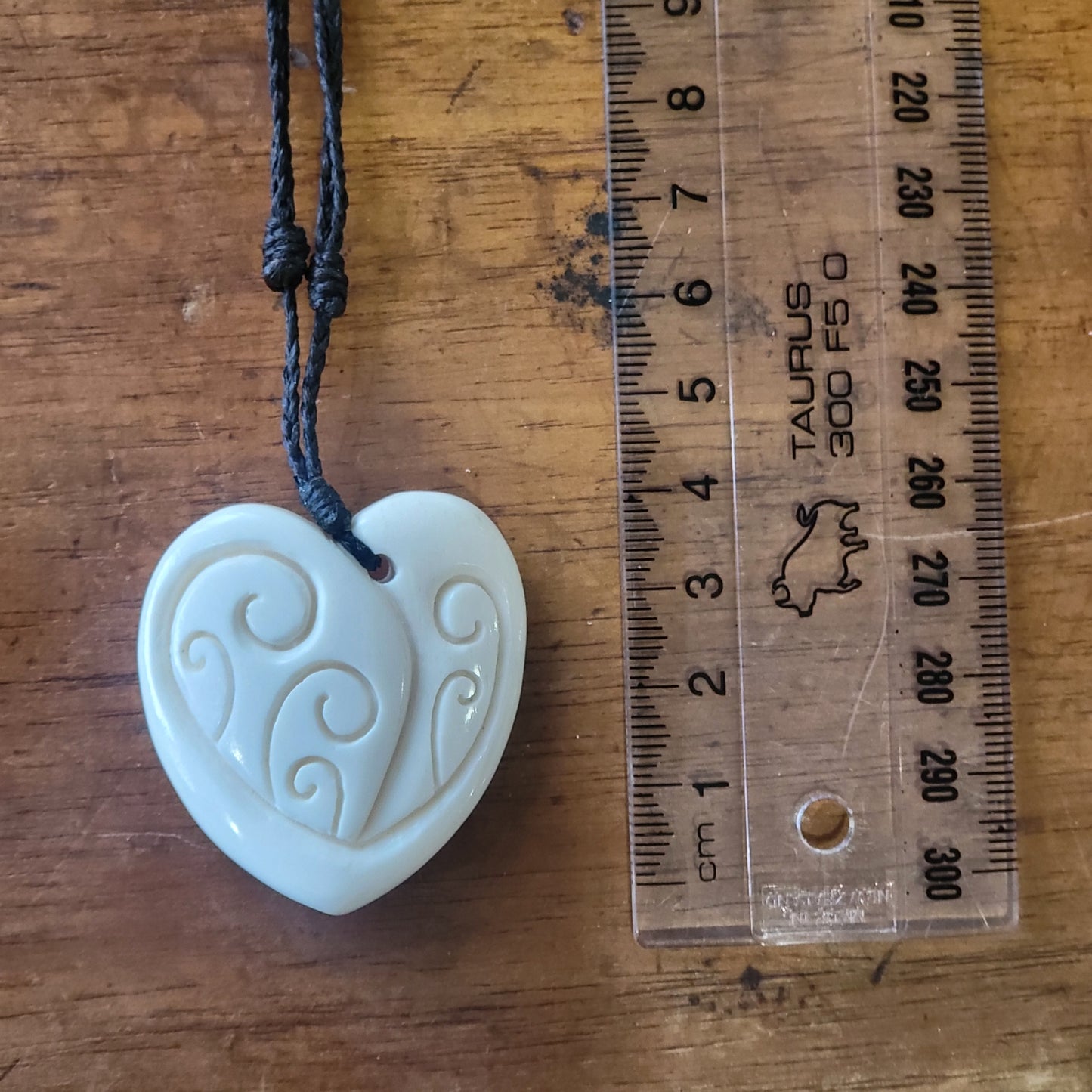 carved bone manawa (heart) necklace on black cord with carved designs