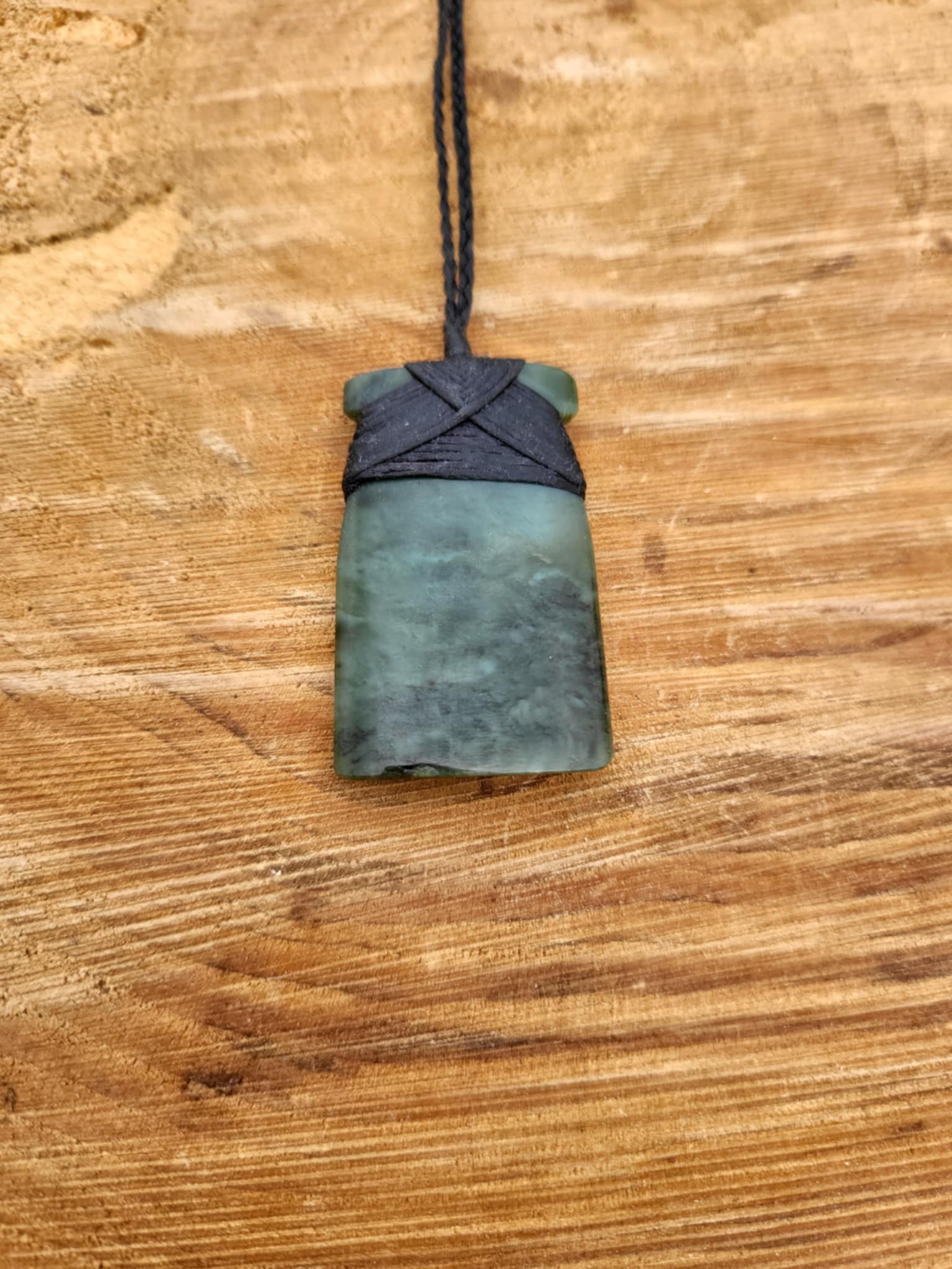 carved pounamu toki (adze) on black cord