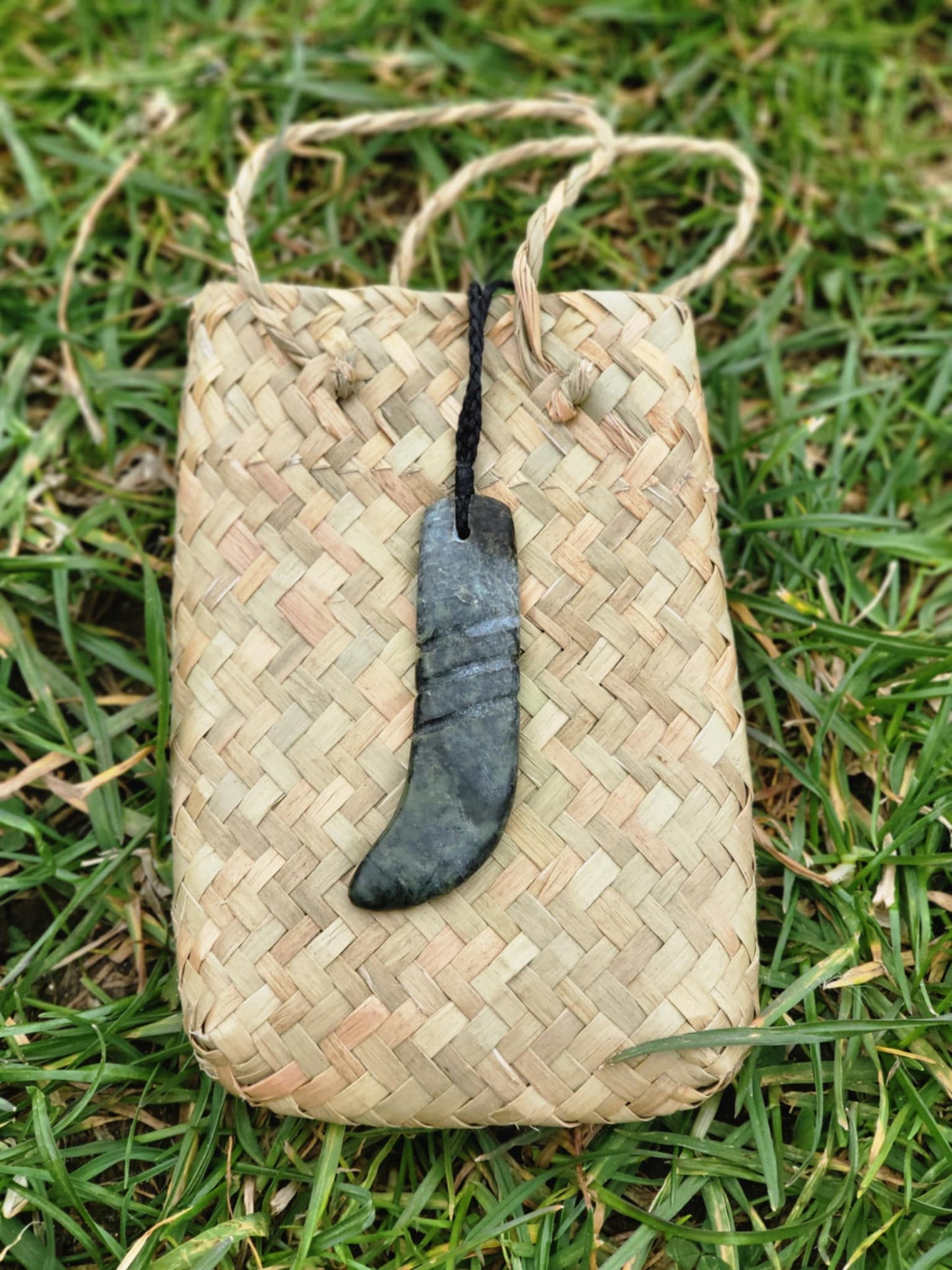 carved pounamu kapeu (notched rod to recite whakapapa) necklace on cord