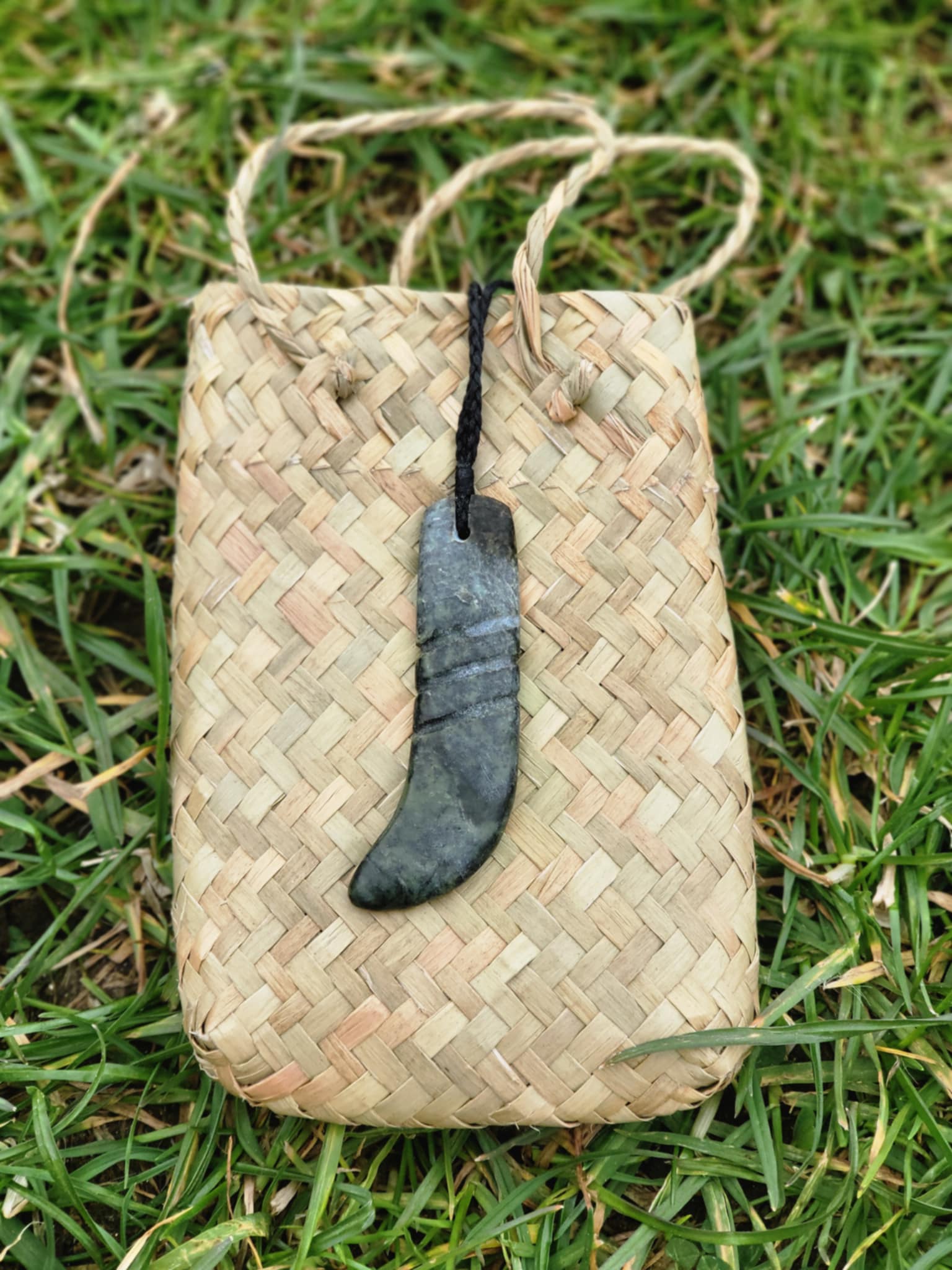carved pounamu kapeu (notched rod to recite whakapapa) necklace on cord