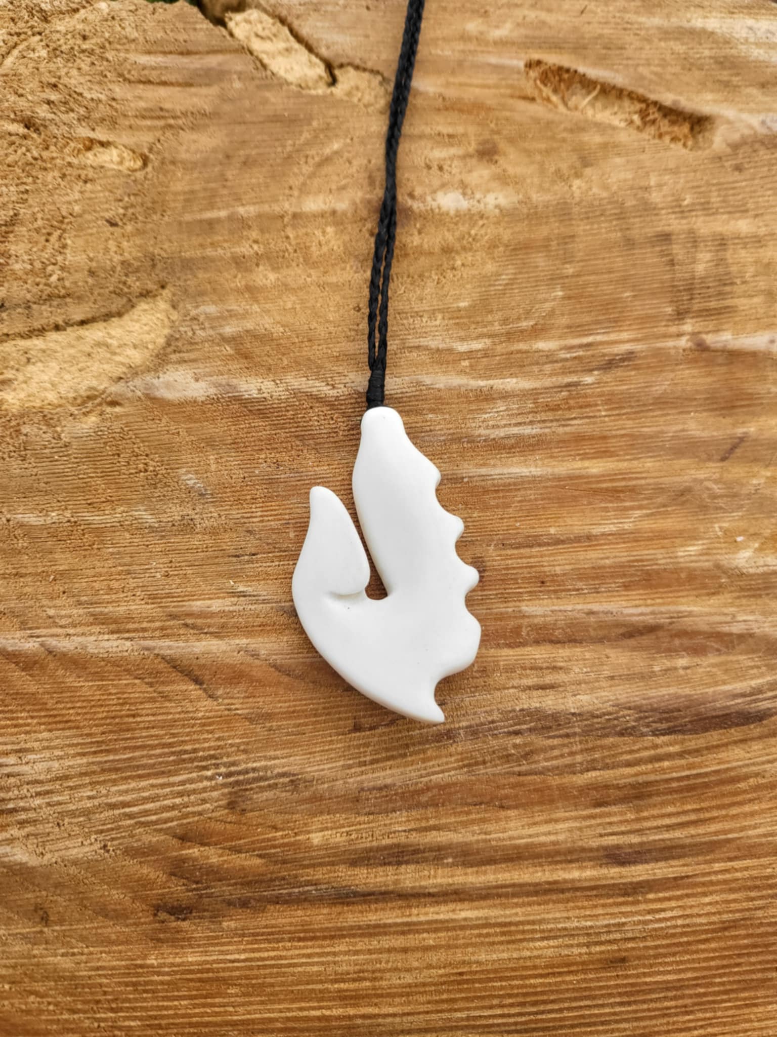 carved bone matau (hook) necklace on black cord