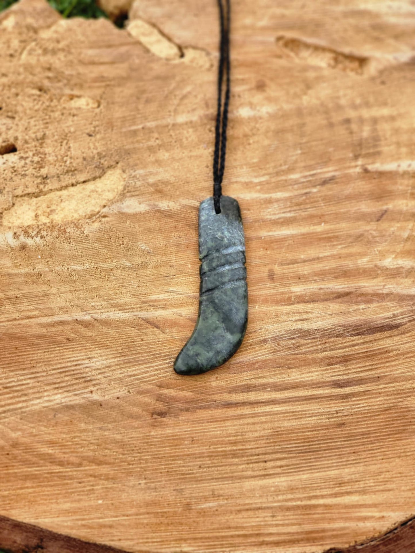 carved pounamu kapeu (notched rod to recite whakapapa) necklace on cord