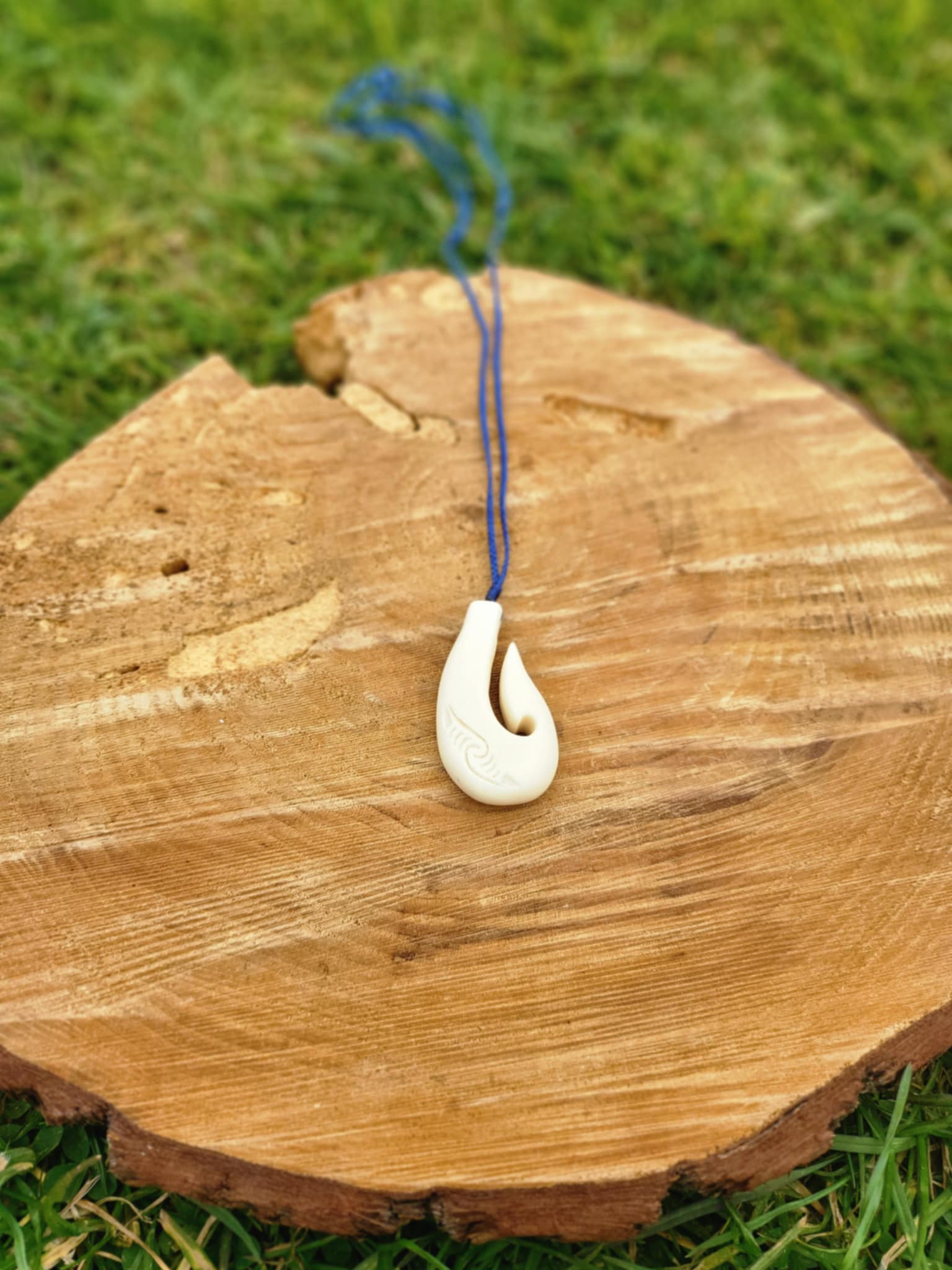 carved bone matau (hook) necklace with koru carvings on black cord