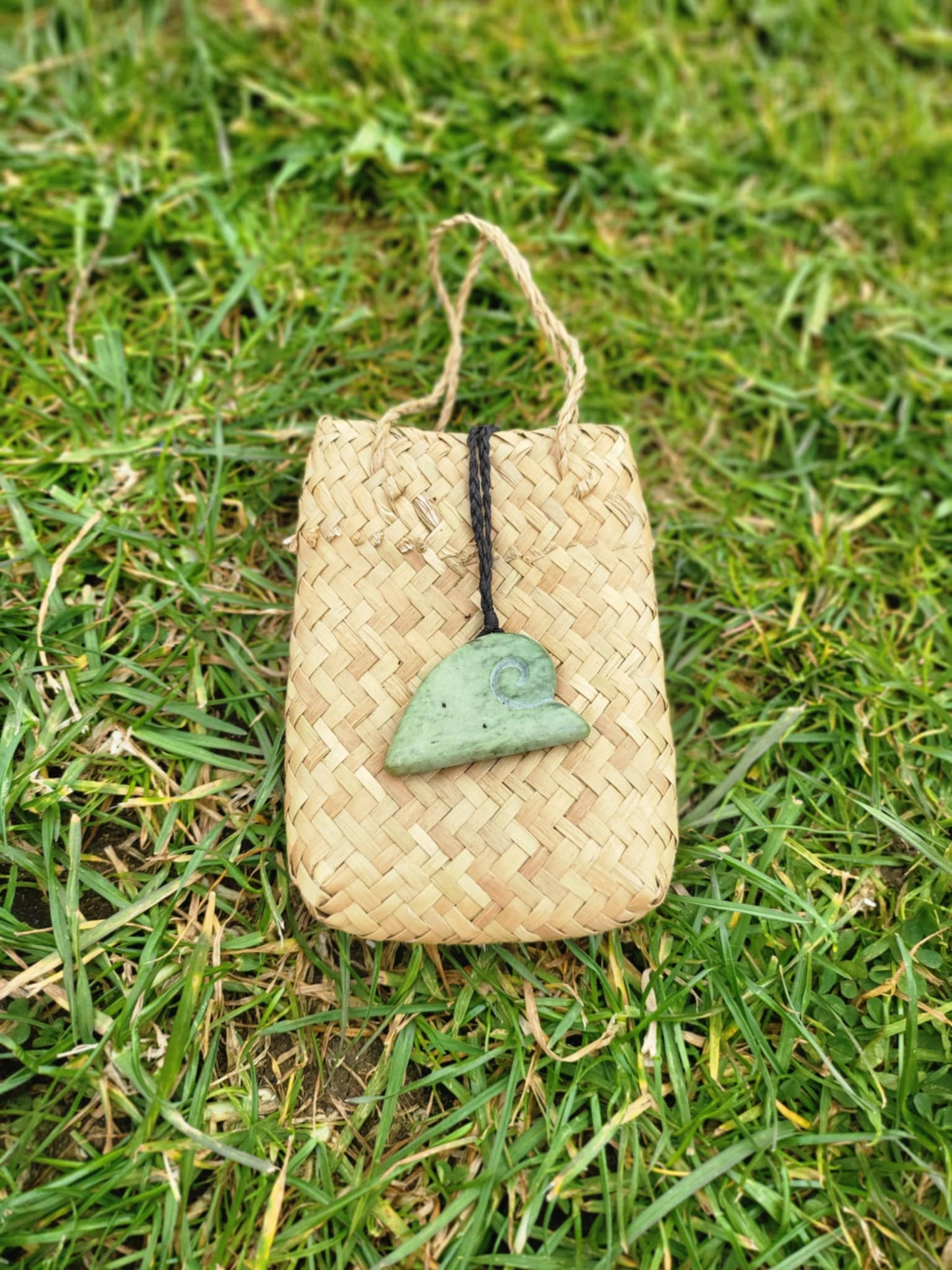 ngaru (wave) carved pounamu necklace on black cord