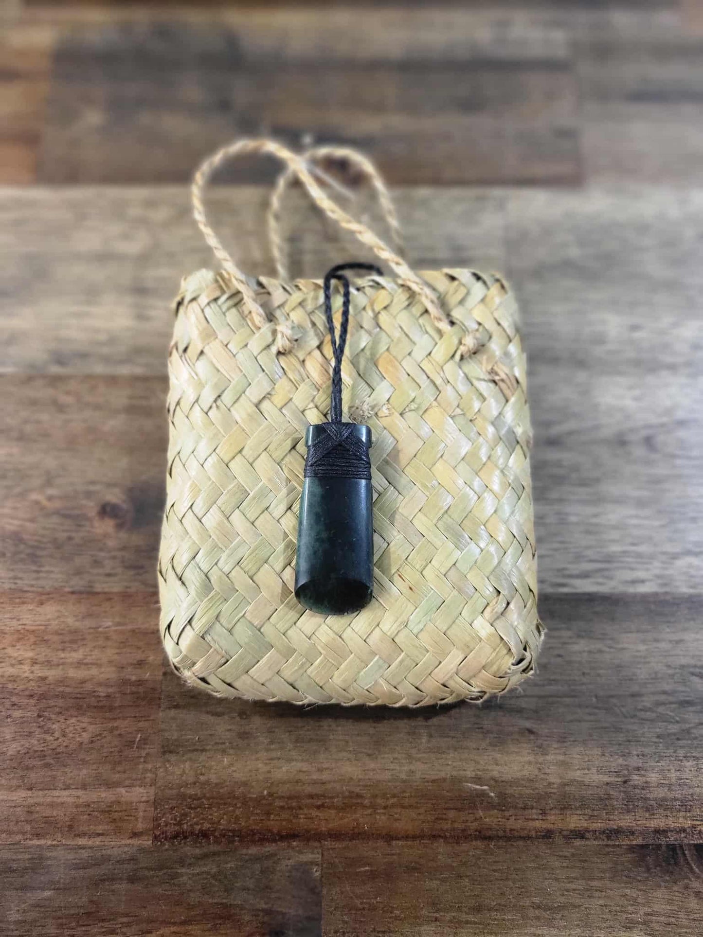 Dark green pounamu greenstone toki (adze) necklace with black strapping