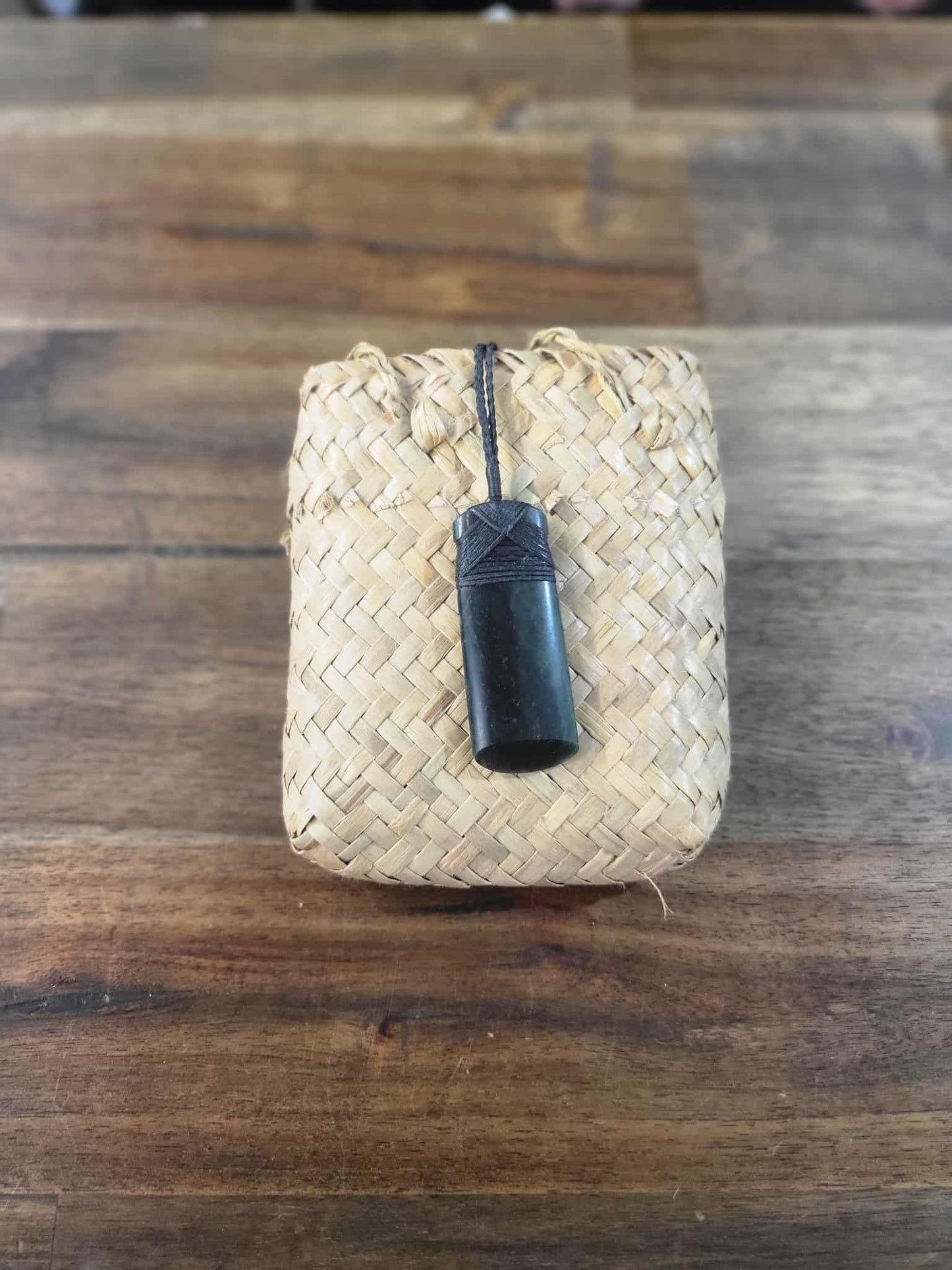 Dark green pounamu greenstone toki (adze) necklace with black strapping