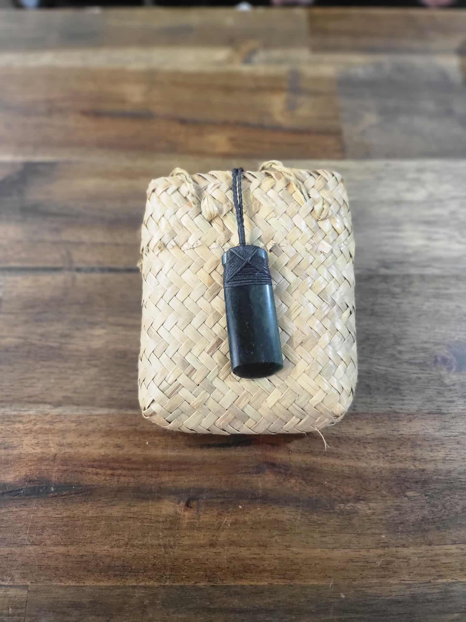 Dark green pounamu greenstone toki (adze) necklace with black strapping