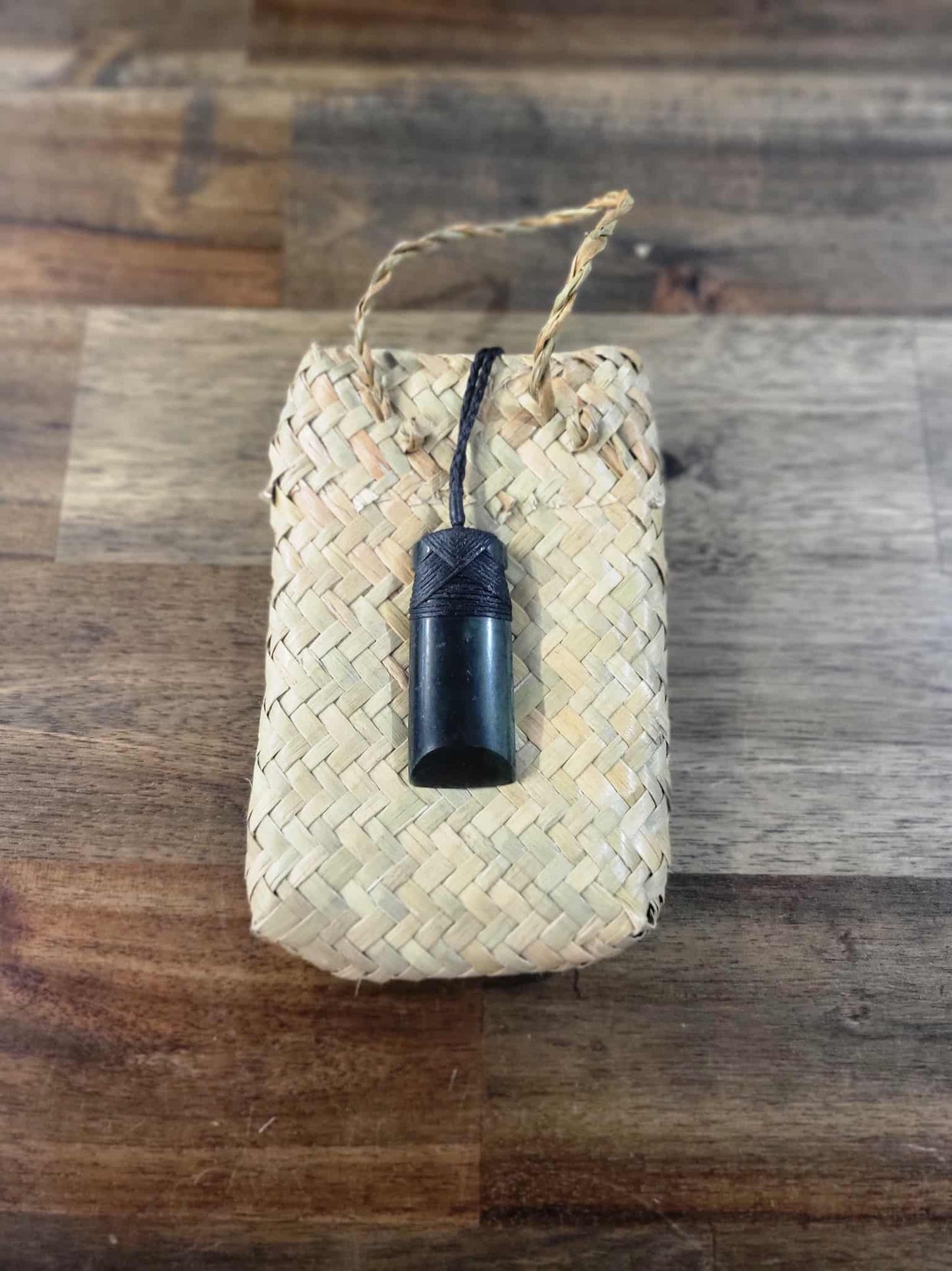 Dark green pounamu greenstone toki (adze) necklace with black strapping