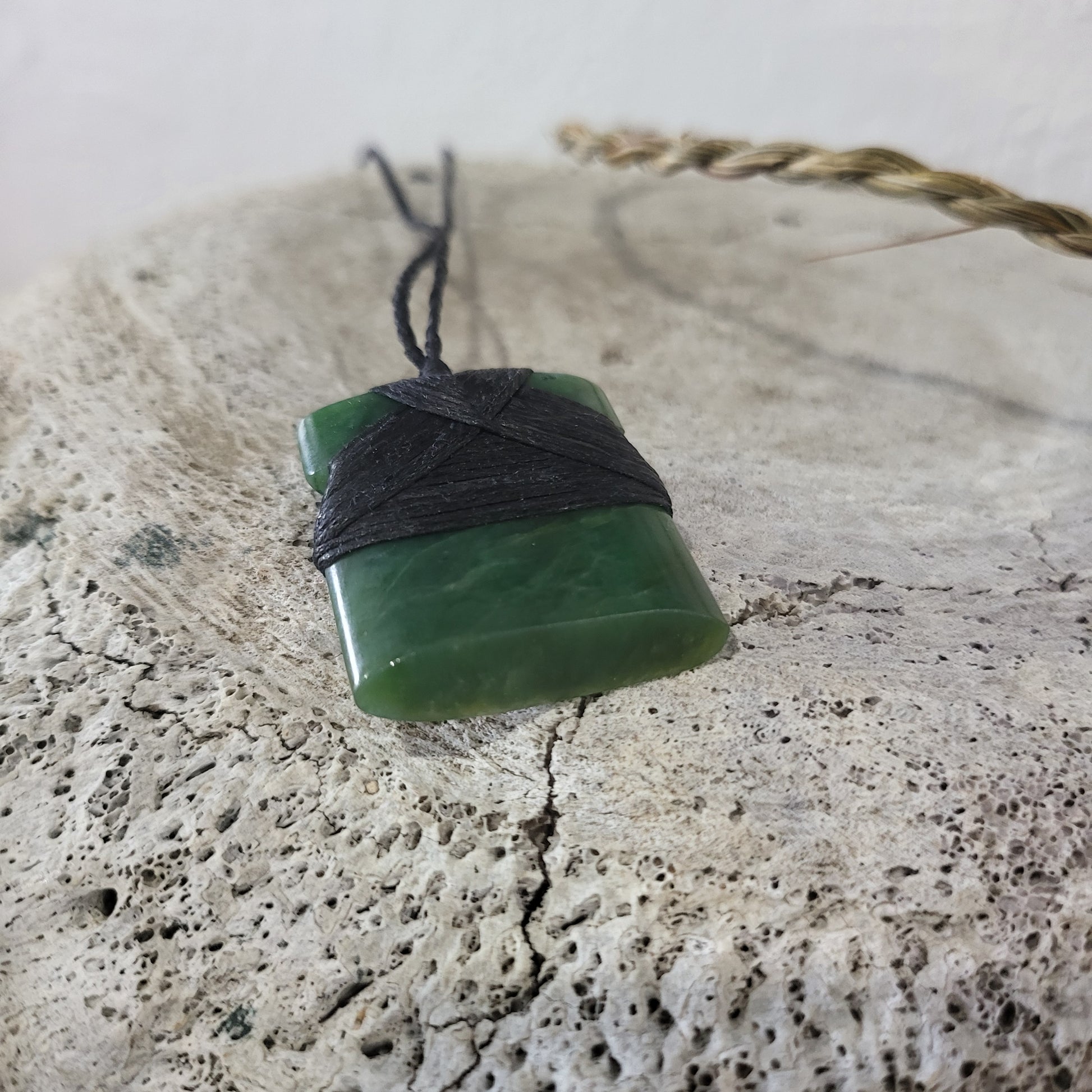 small carved pounamu toki (adze) necklace, on black cord