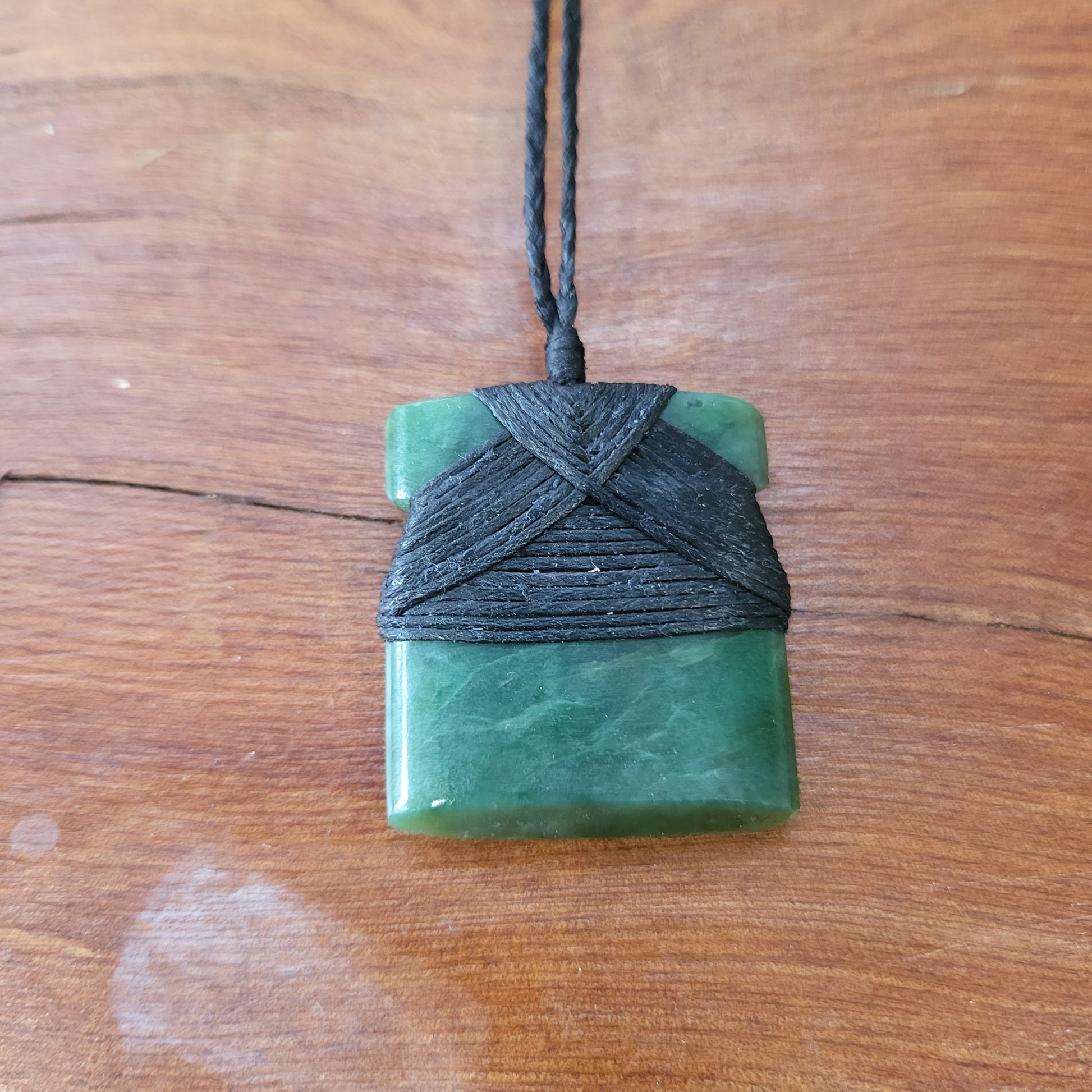 small carved pounamu toki (adze) necklace, on black cord