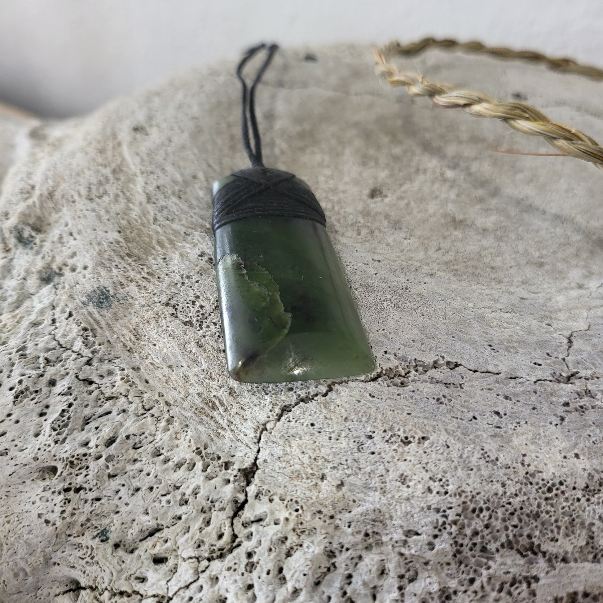 carved pounamu toki (adze) necklace, beautiful colour variations, on black cord