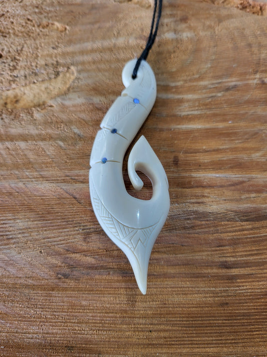 carved bone and paua matau (hook) necklace on black cord, with carved patterns
