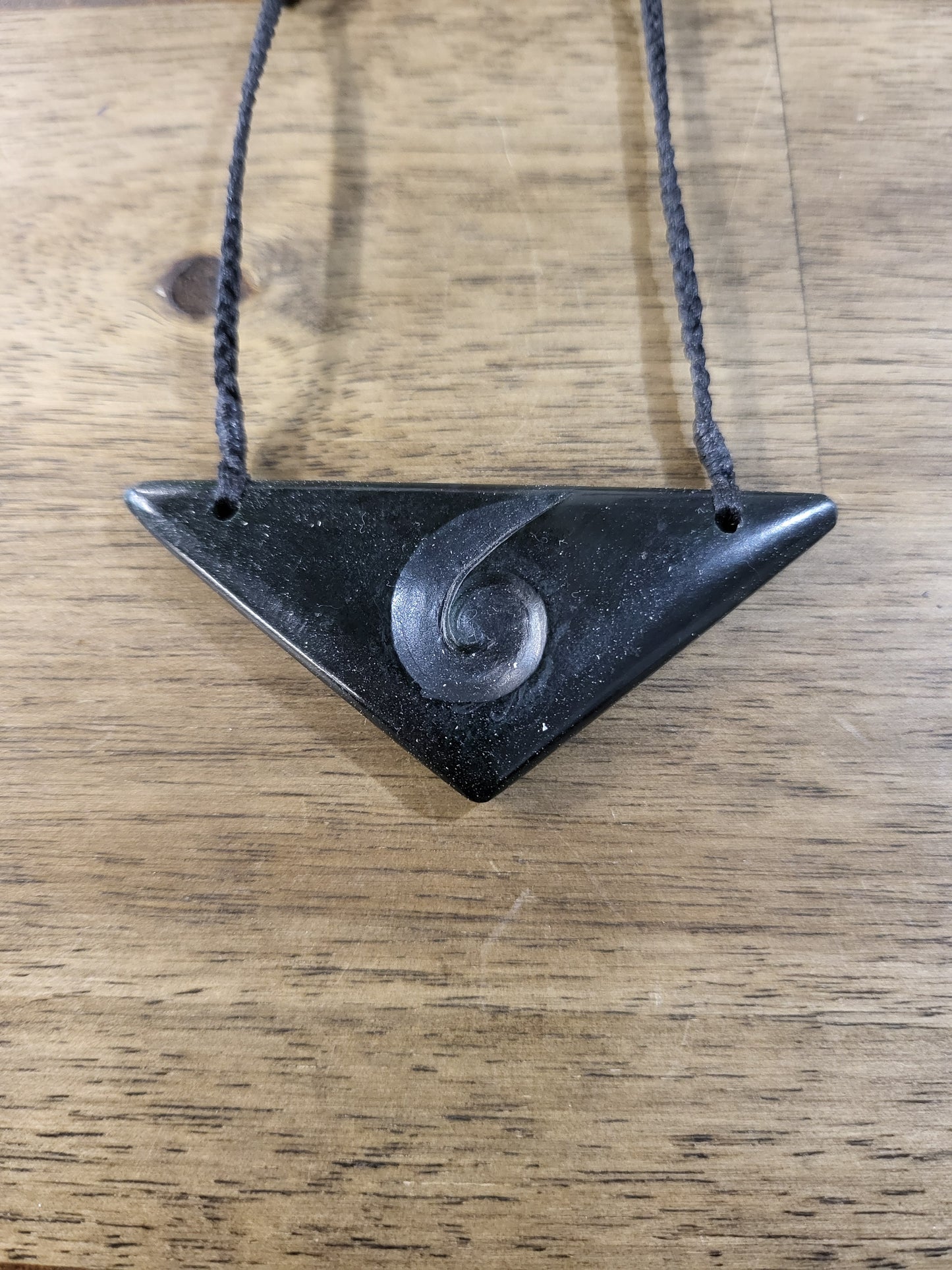 carved pounamu chest plate necklace on black cord with koru design