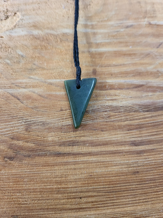 small carved pounamu niho (tooth) necklace on black cord