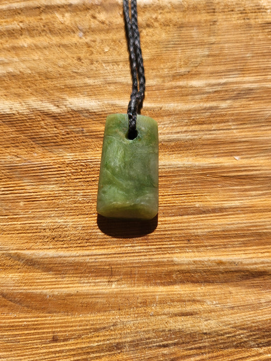 small carved pounamu toki (adze) necklace on black cord