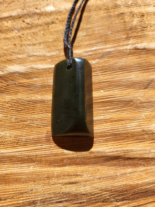 small carved pounamu toki (adze) necklace on black cord