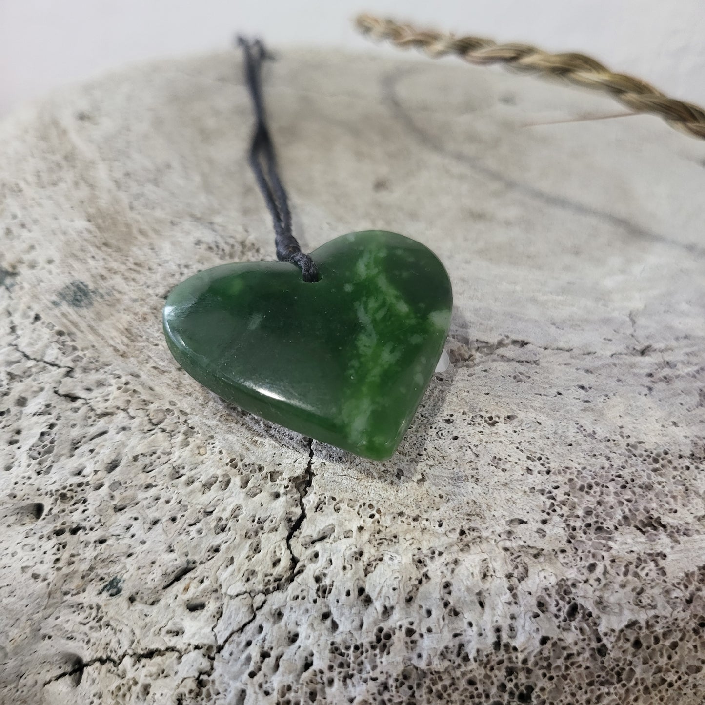 carved pounamu manawa (heart) necklace, beautiful colour variations, on black cord