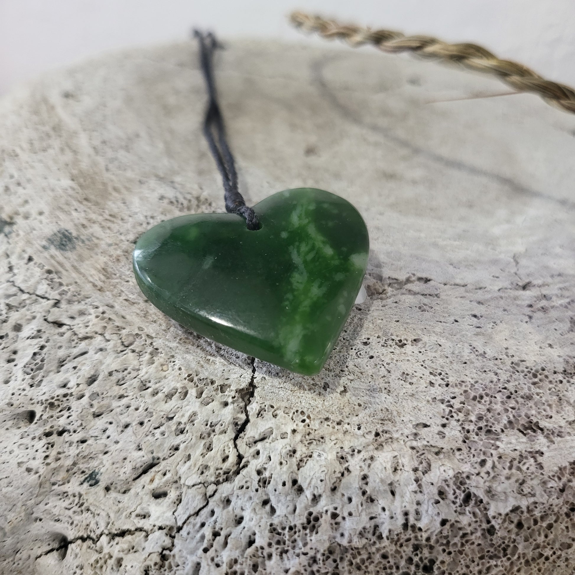 carved pounamu manawa (heart) necklace, beautiful colour variations, on black cord