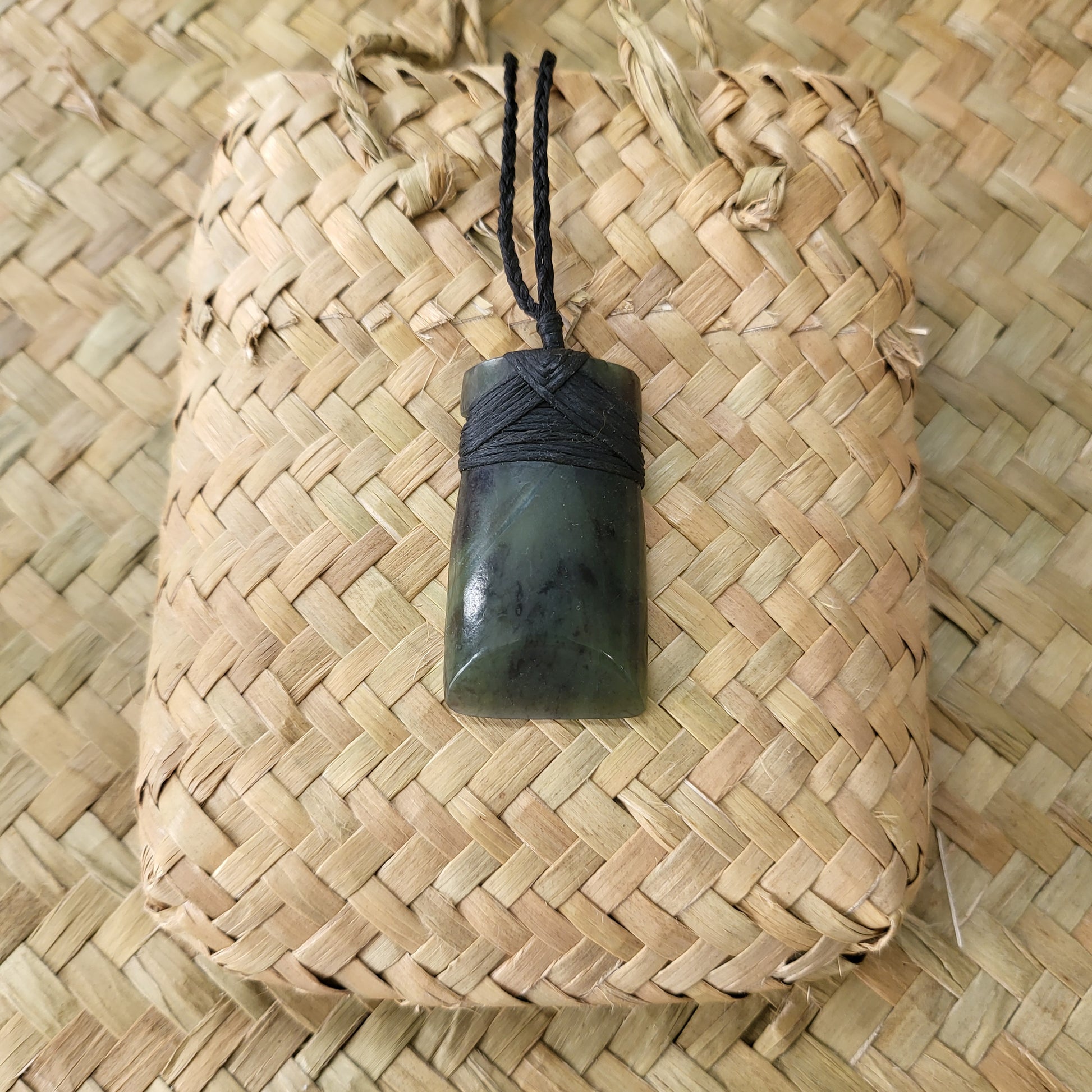 carved pounamu toki (adze) necklace, beautiful colour variations, on black cord