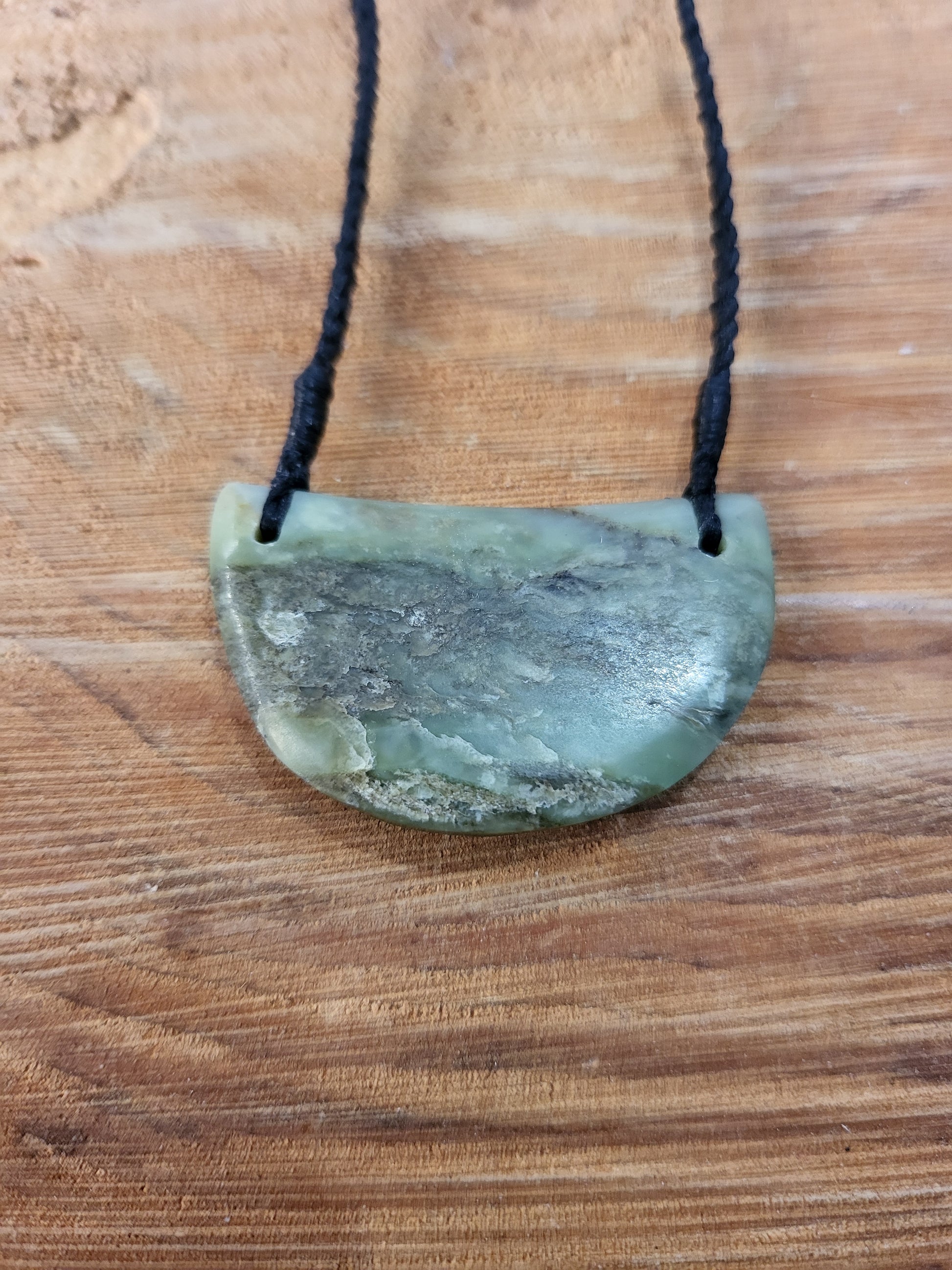 carved pounamu chest plate necklace on black cord