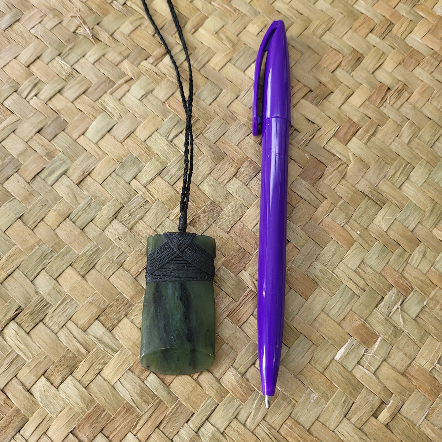 carved pounamu toki (adze) necklace, beautiful colour variations, on black cord