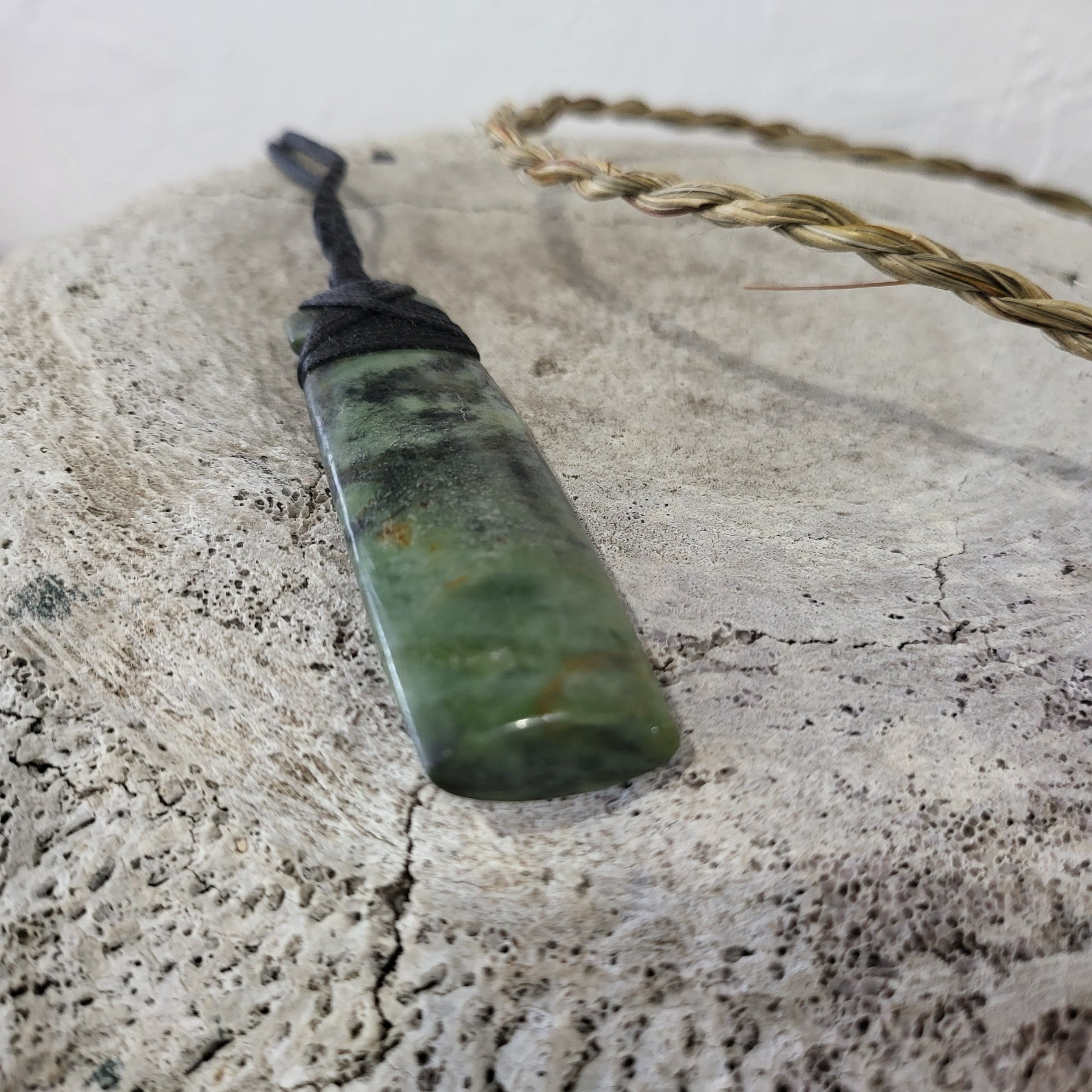 carved pounamu toki (adze) necklace light green colour variations on black cord