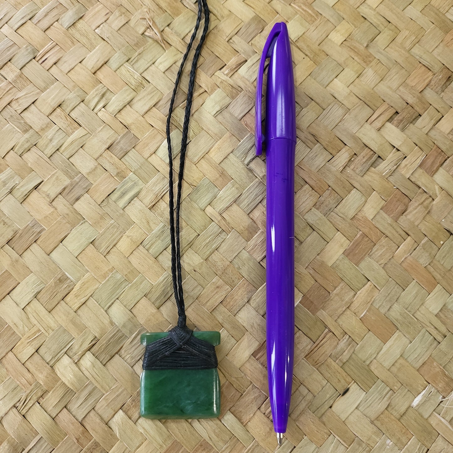 small carved pounamu toki (adze) necklace, on black cord