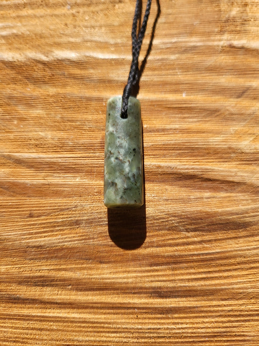 small carved pounamu toki (adze) necklace on black cord