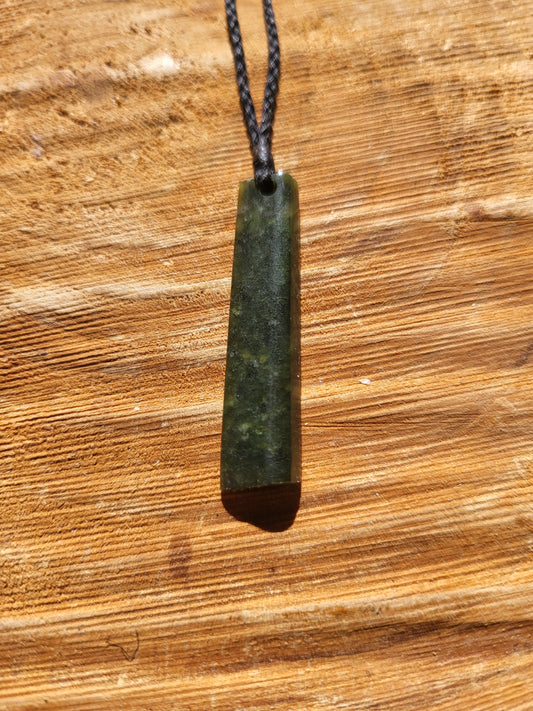 small carved pounamu toki (adze) necklace on black cord