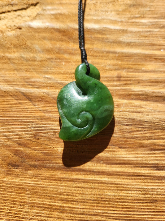carved pounamu pikorua (double twist) necklace on black cord, beautiful colour variations