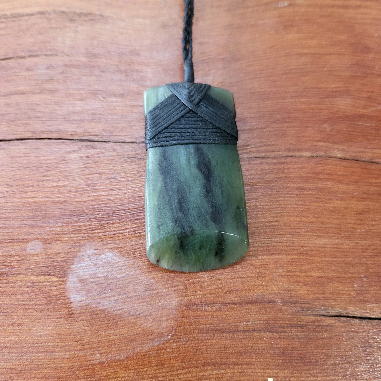 carved pounamu toki (adze) necklace, beautiful colour variations, on black cord