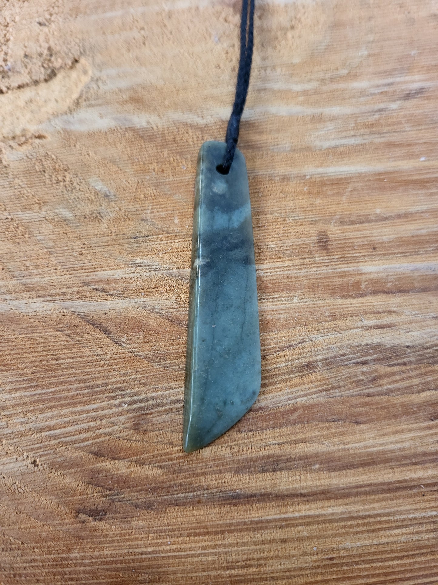 small carved pounamu toki (adze) necklace on black cord