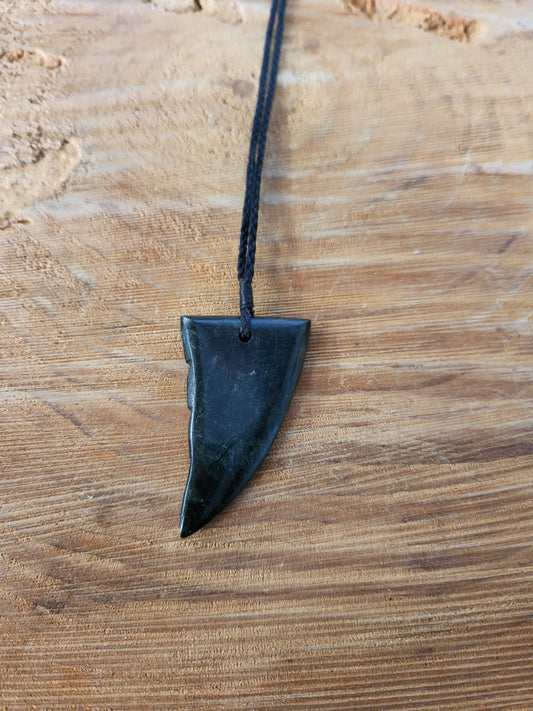small carved pounamu niho (tooth) necklace on black cord