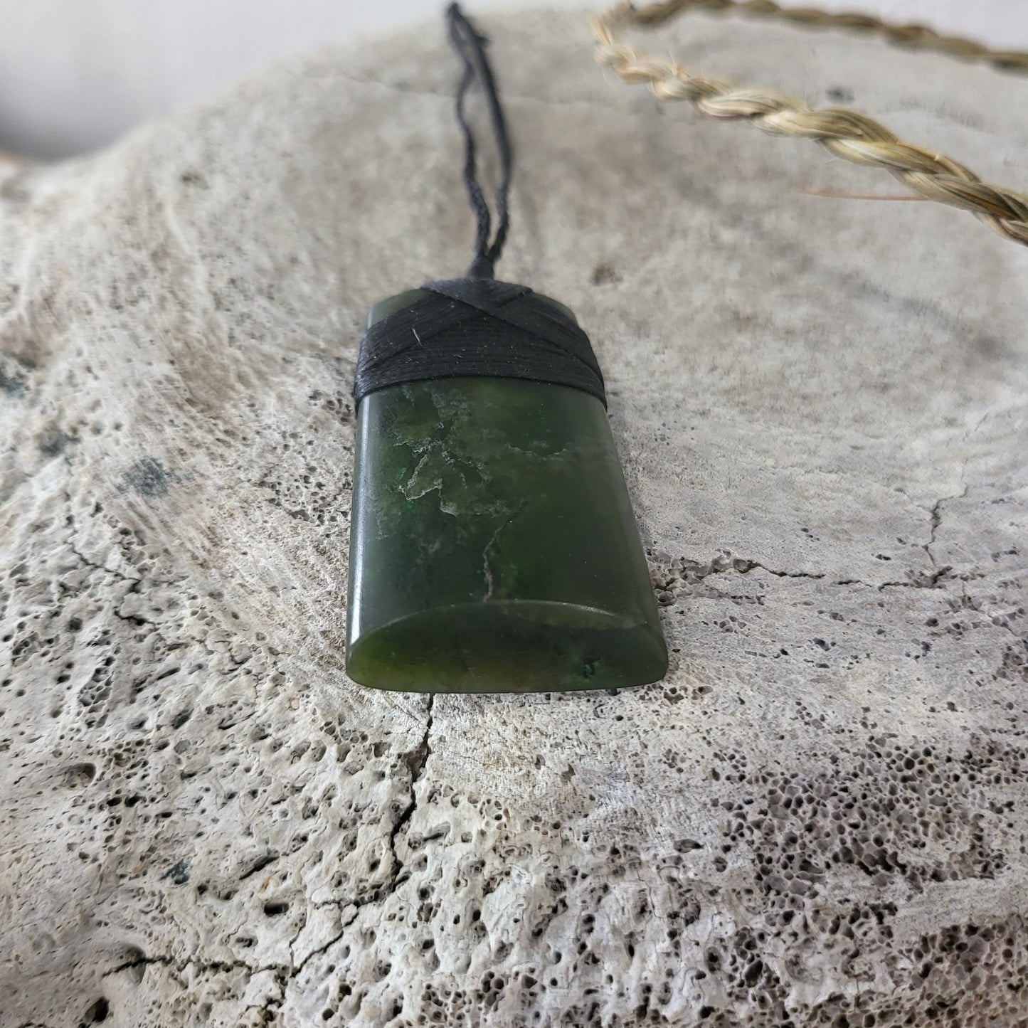 carved pounamu toki (adze) necklace, beautiful colour variations, on black cord